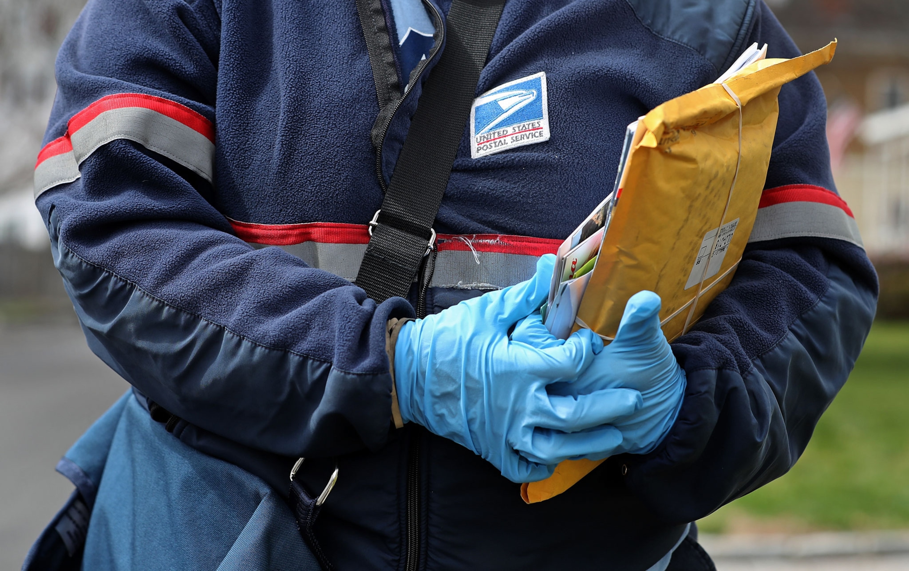 a postal worker wearing rubber gloves and mail