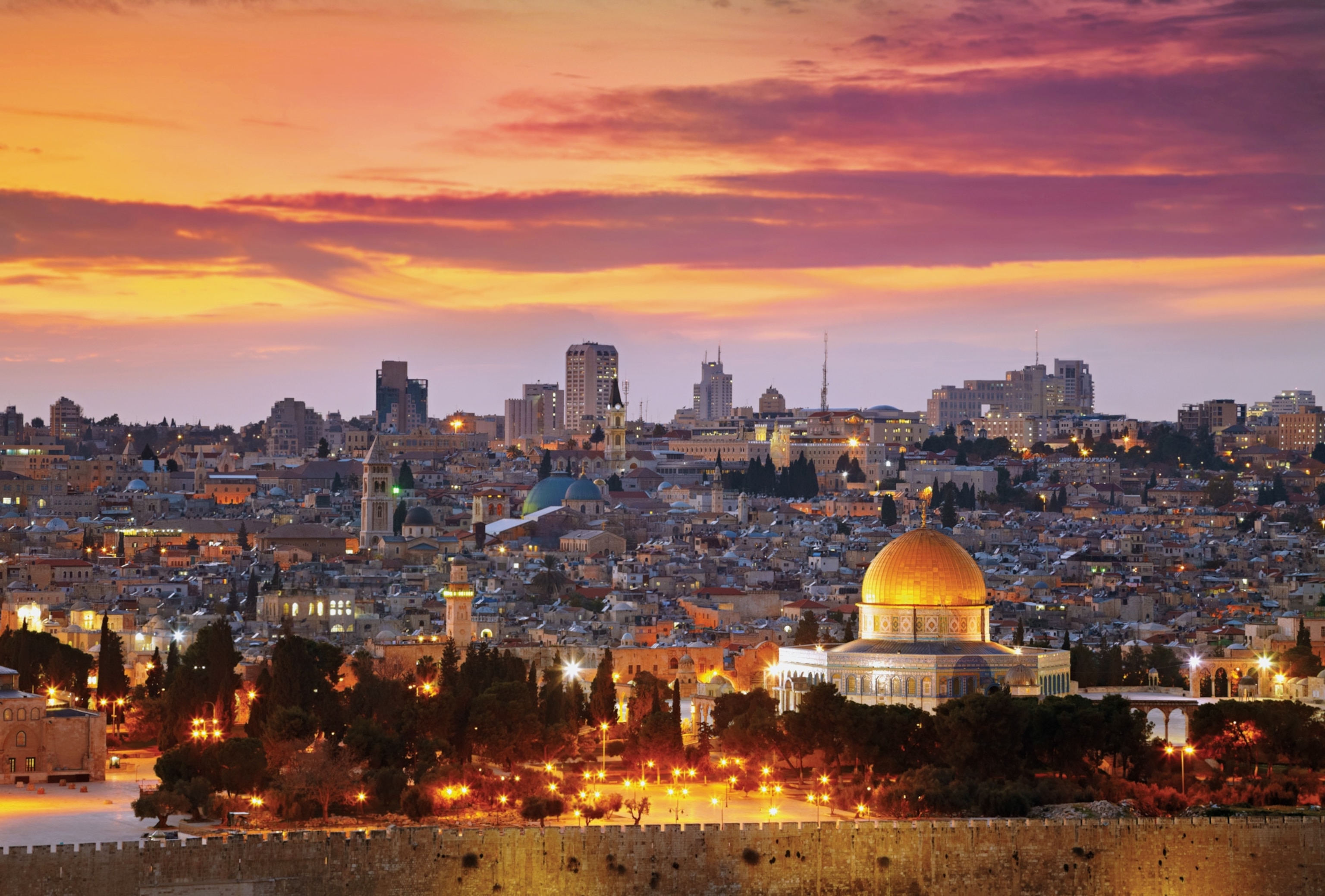 Photo of mosque with gold roof against sunset skyline of Jerusalem