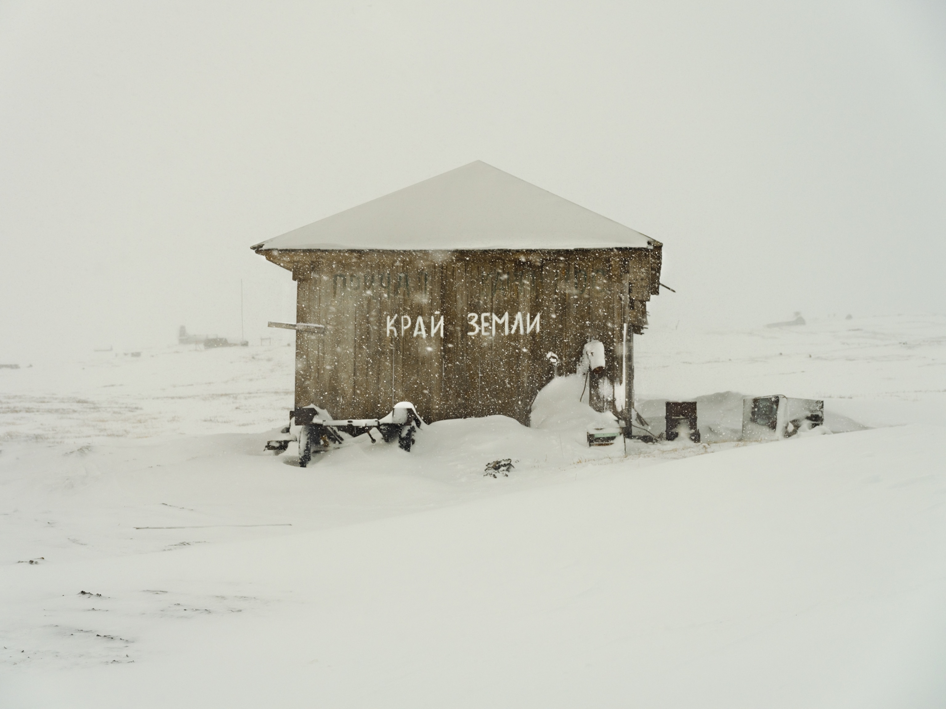 the sign painting with white on brown shack.