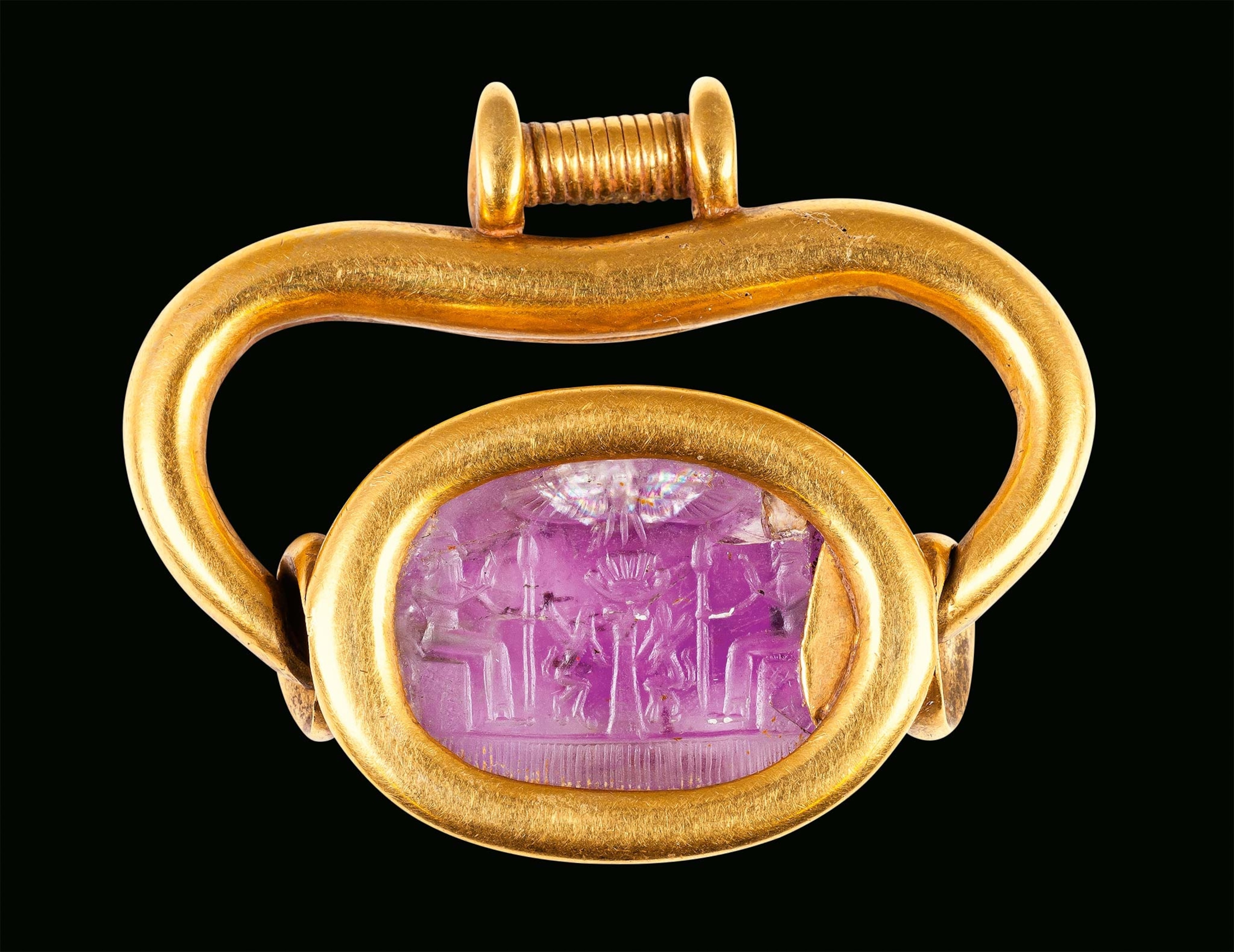 Two enthroned divinities face each other in the image on a swivel pendant on a ring