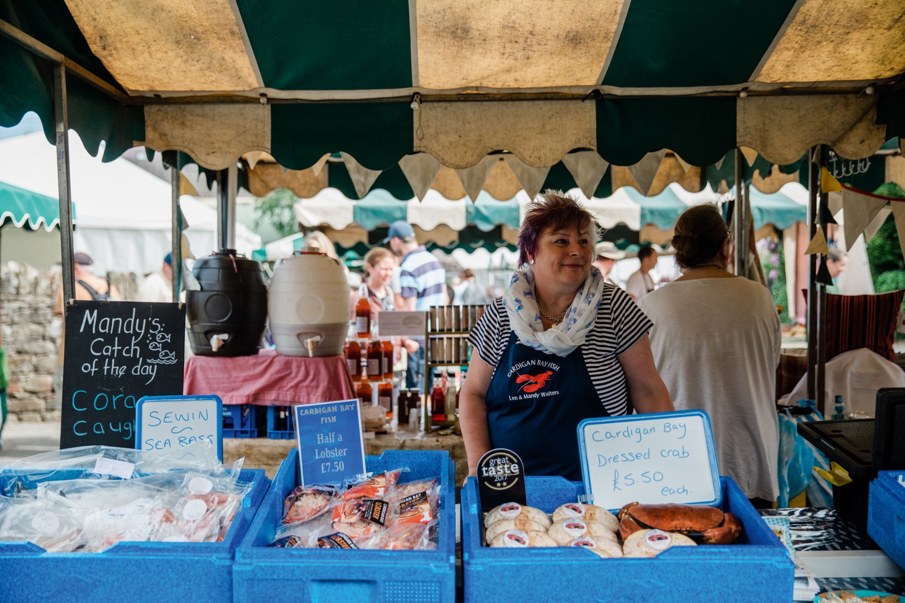 Woman standing at a fish stall with fish in ice trays