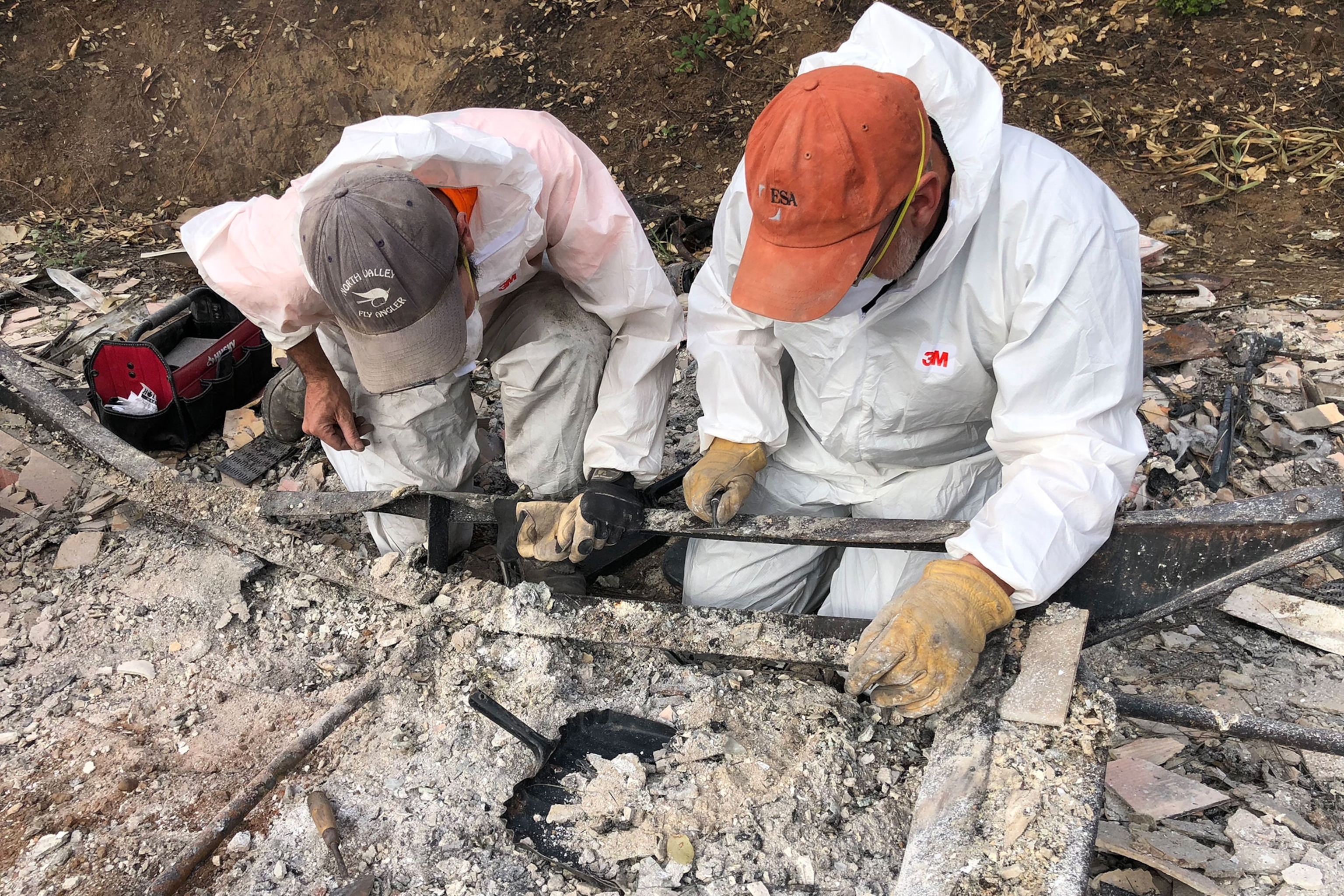 archaeologists recovering cremains from a burned-out trailer home