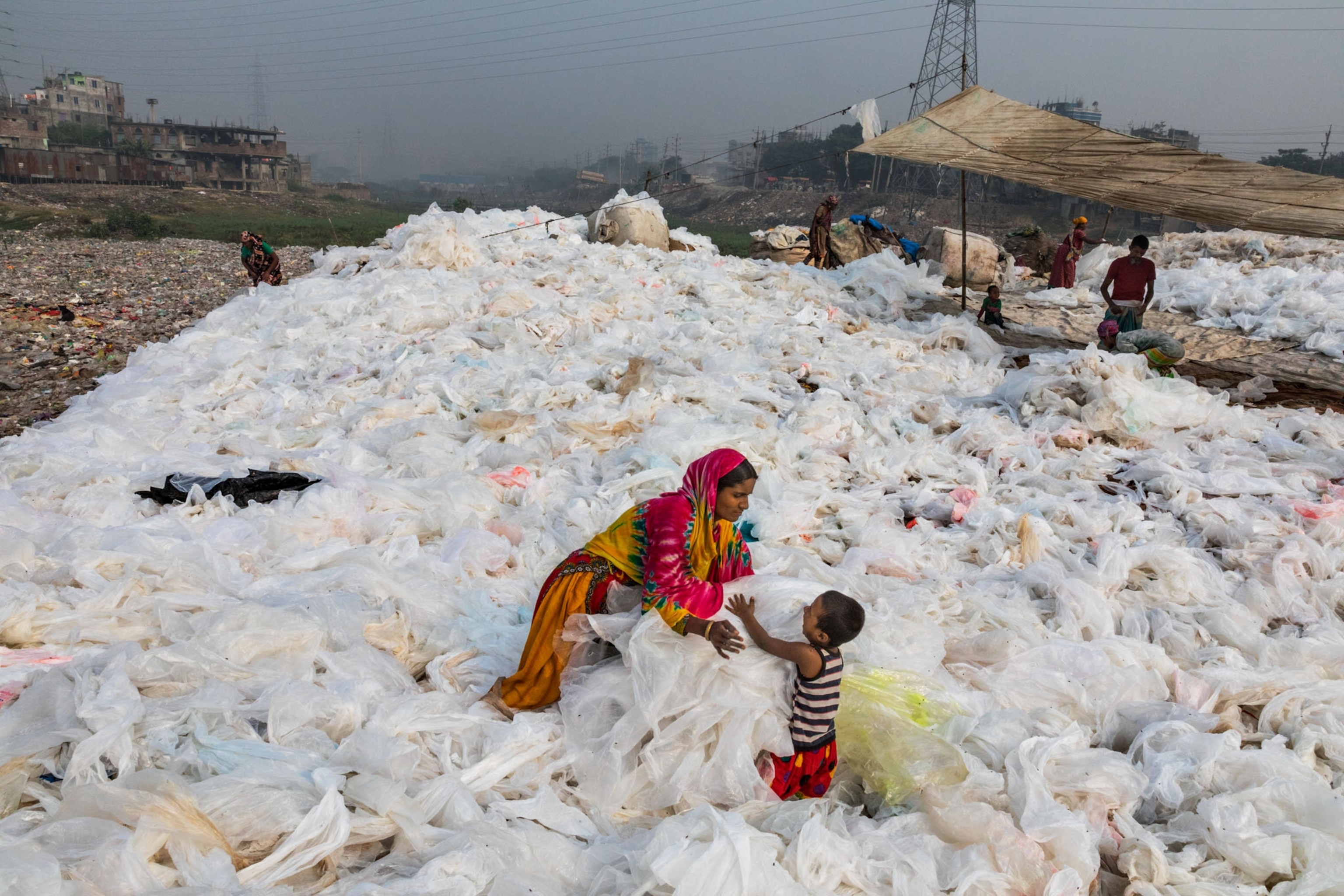 a woman and her son immersed in a landscape of plastic white sheets