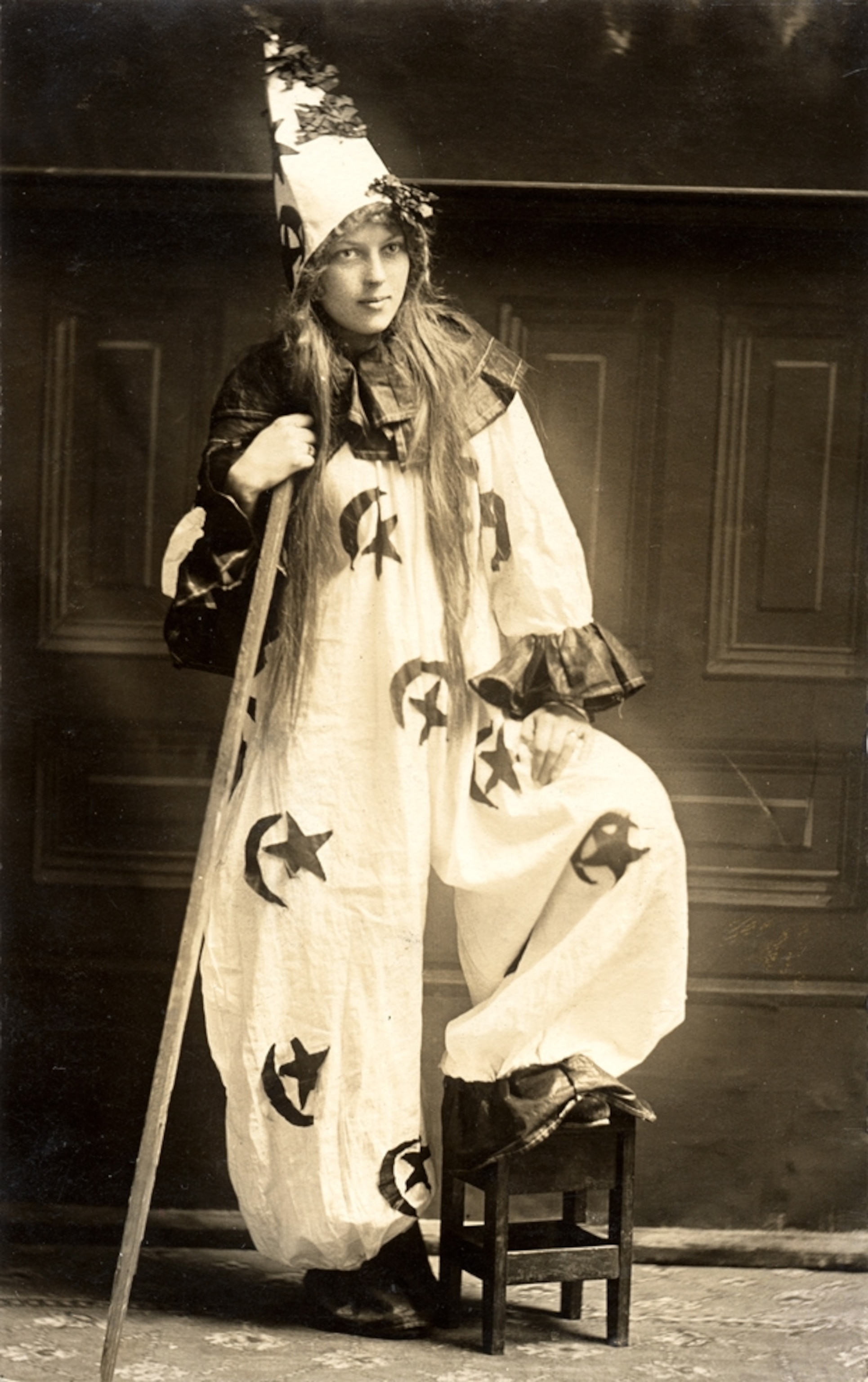 a woman wearing a clown, witch, or sorcerer Halloween costume.