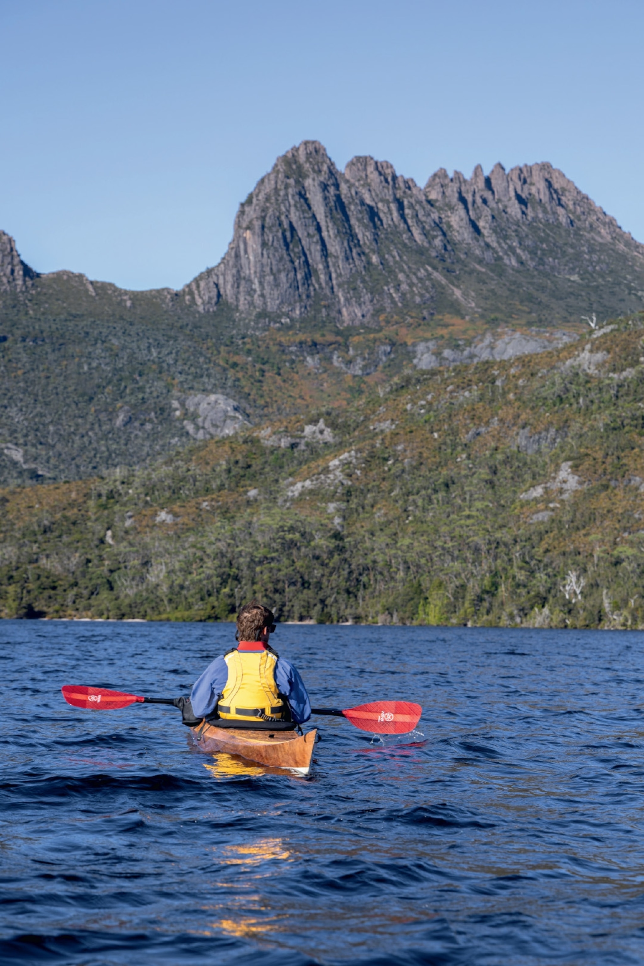 man on kayak looking at mountains