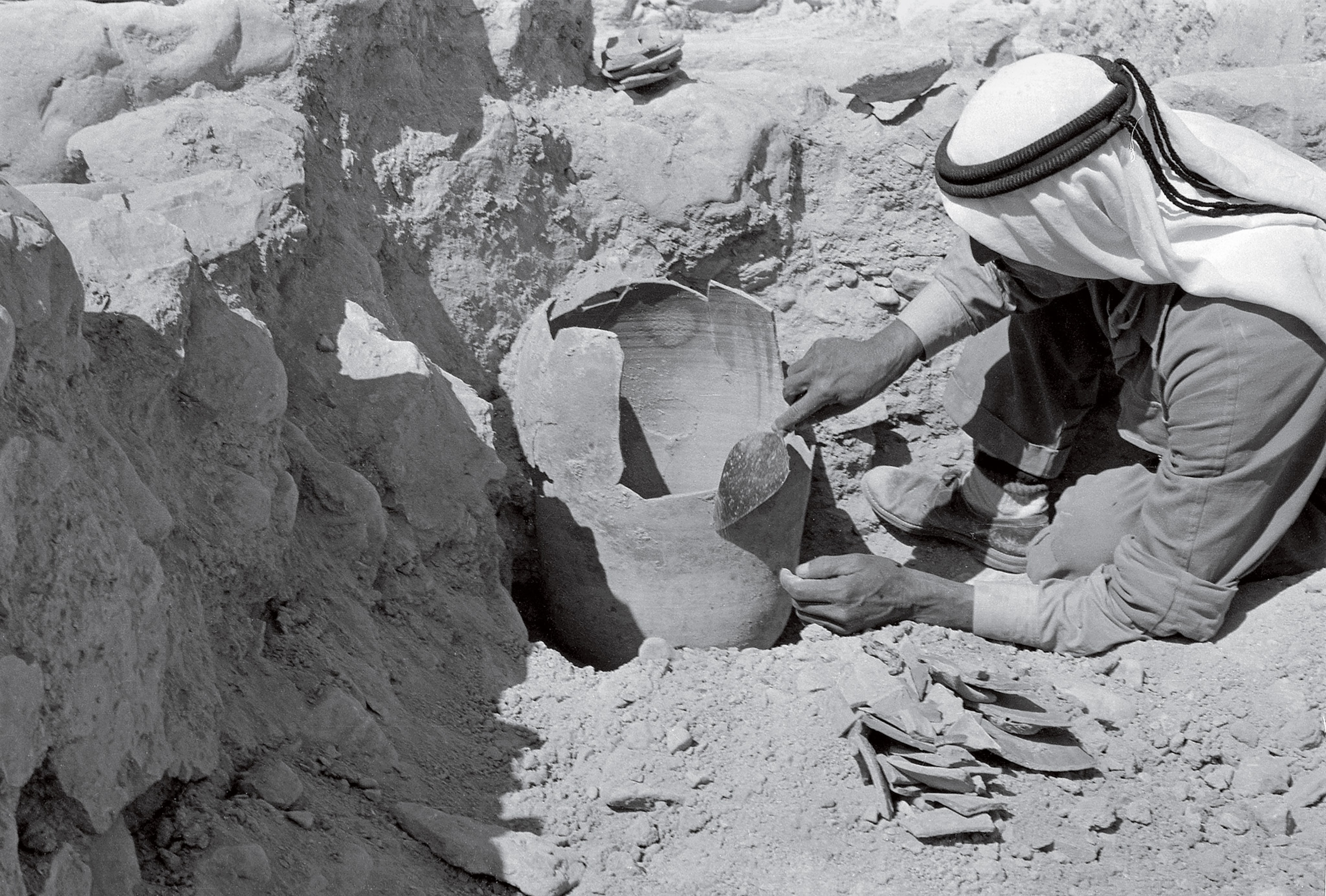A Bedouin excavator uncovers a vessel near the Qumran settlement in 1954.