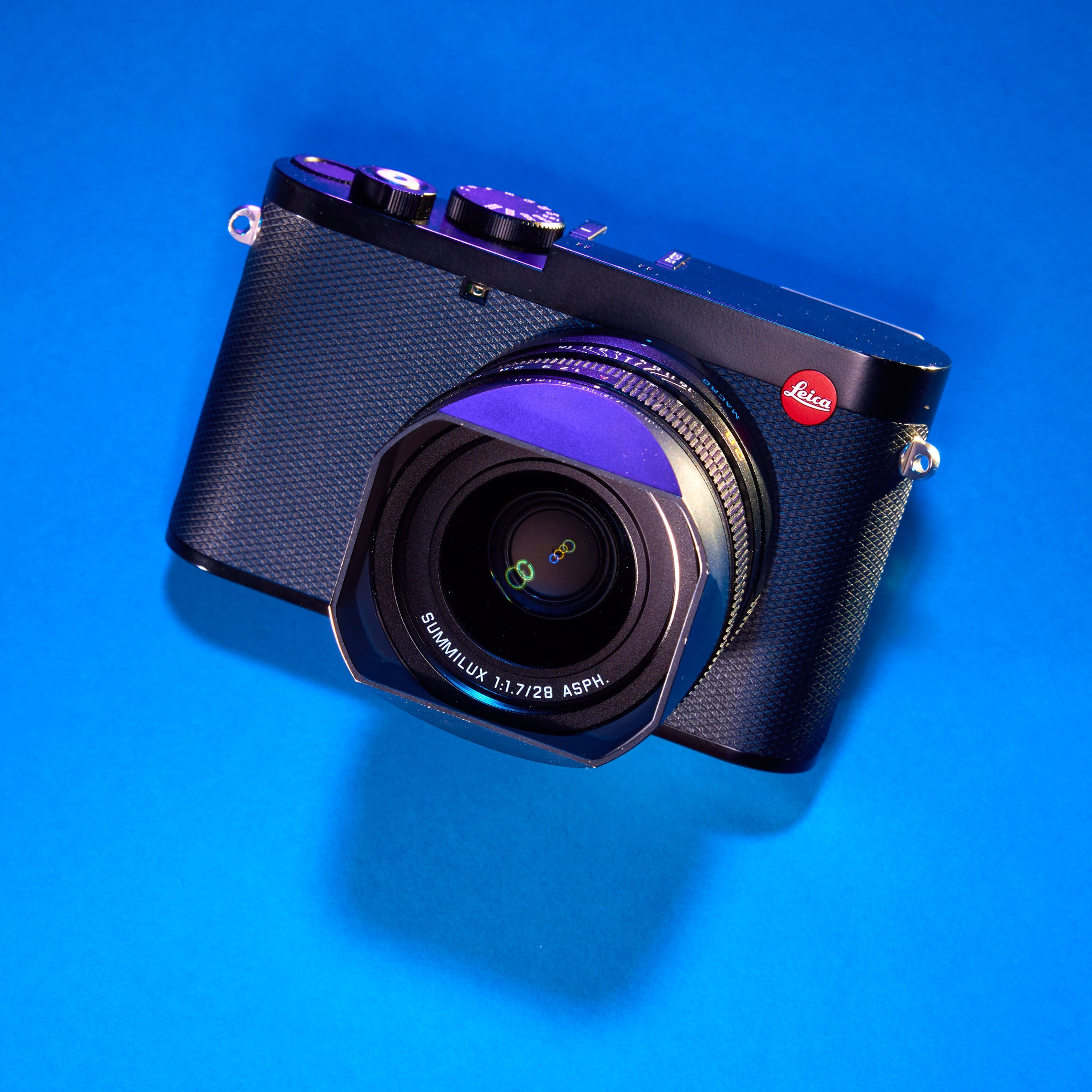 Studio photograph of the Leica Q3 against a blue background