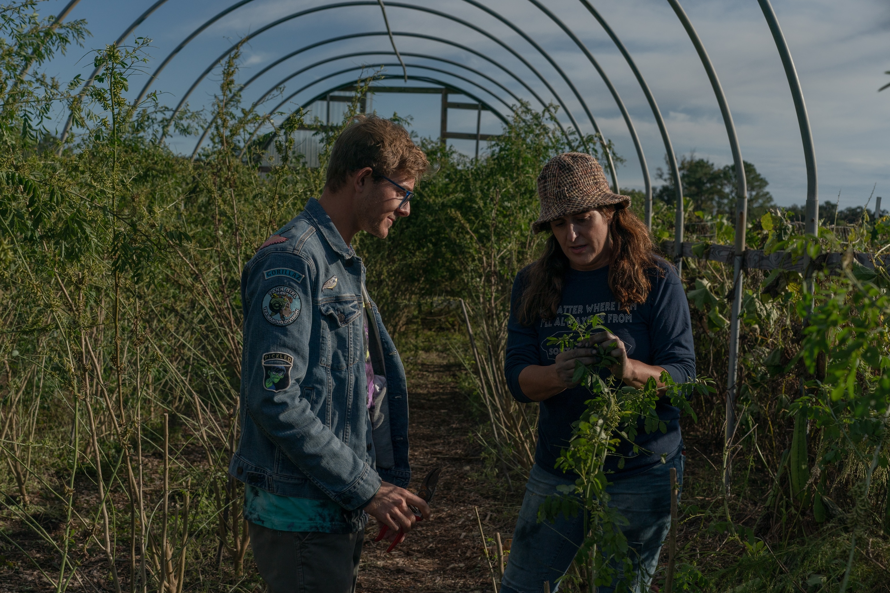 Ellie Maas Davis (right) shows Nathaniel Watkins an indigo plant during a free community indigo dyeing workshop