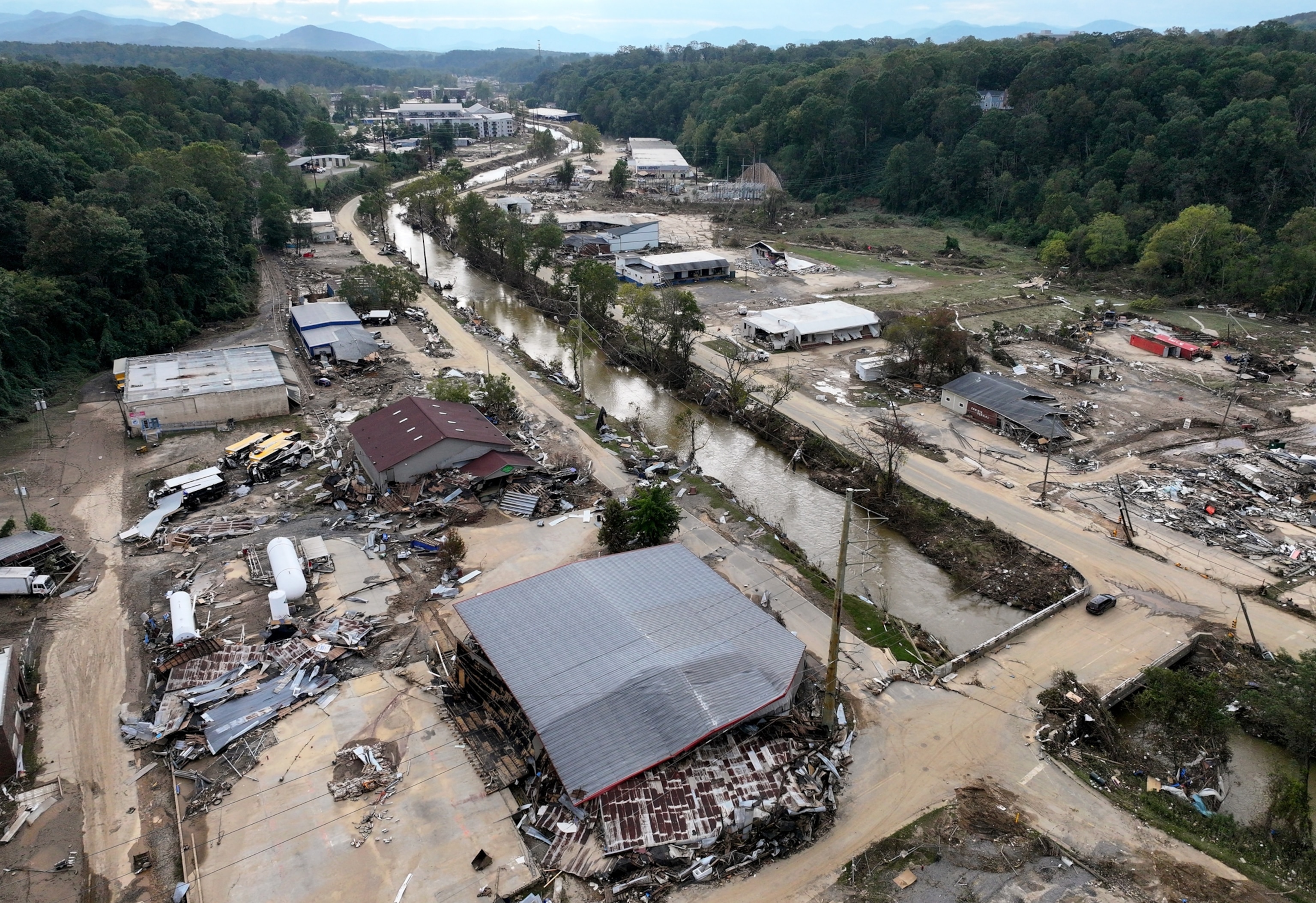 An aerial view of destroyed buildings and roads covered in mud.