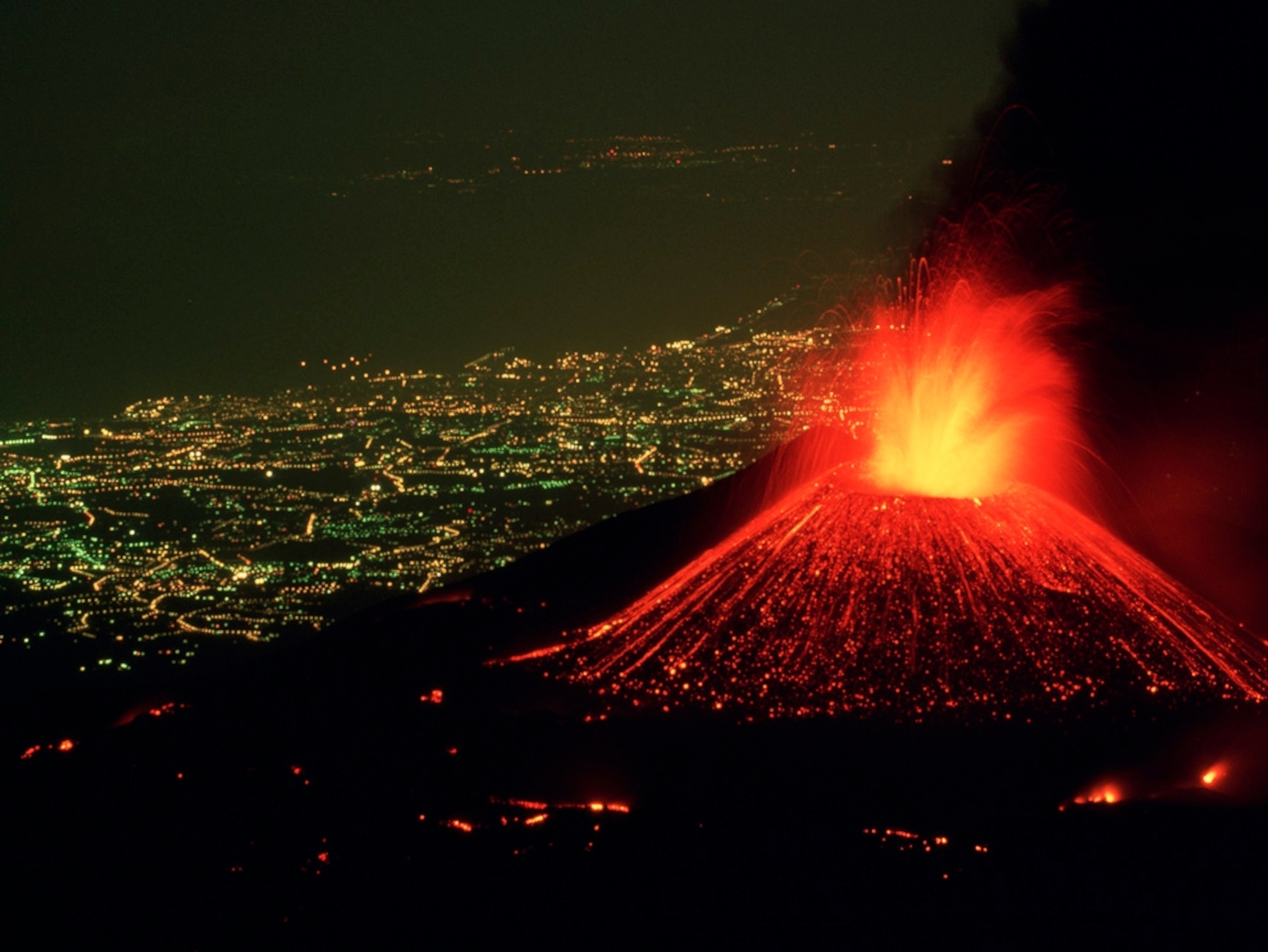 City lights near an erupting volcano
