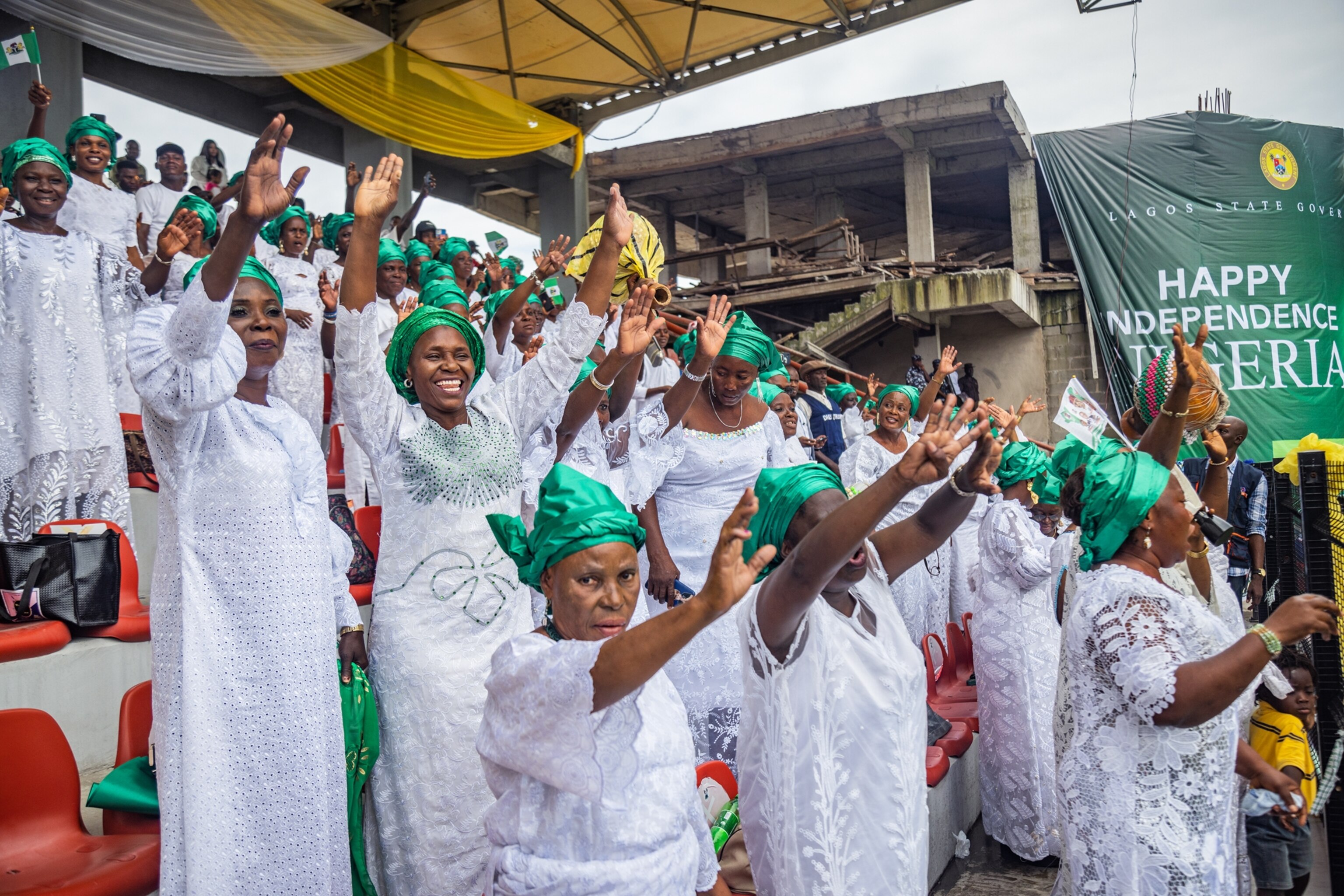Picture of women dressed in white dresses and emerald green head wraps.