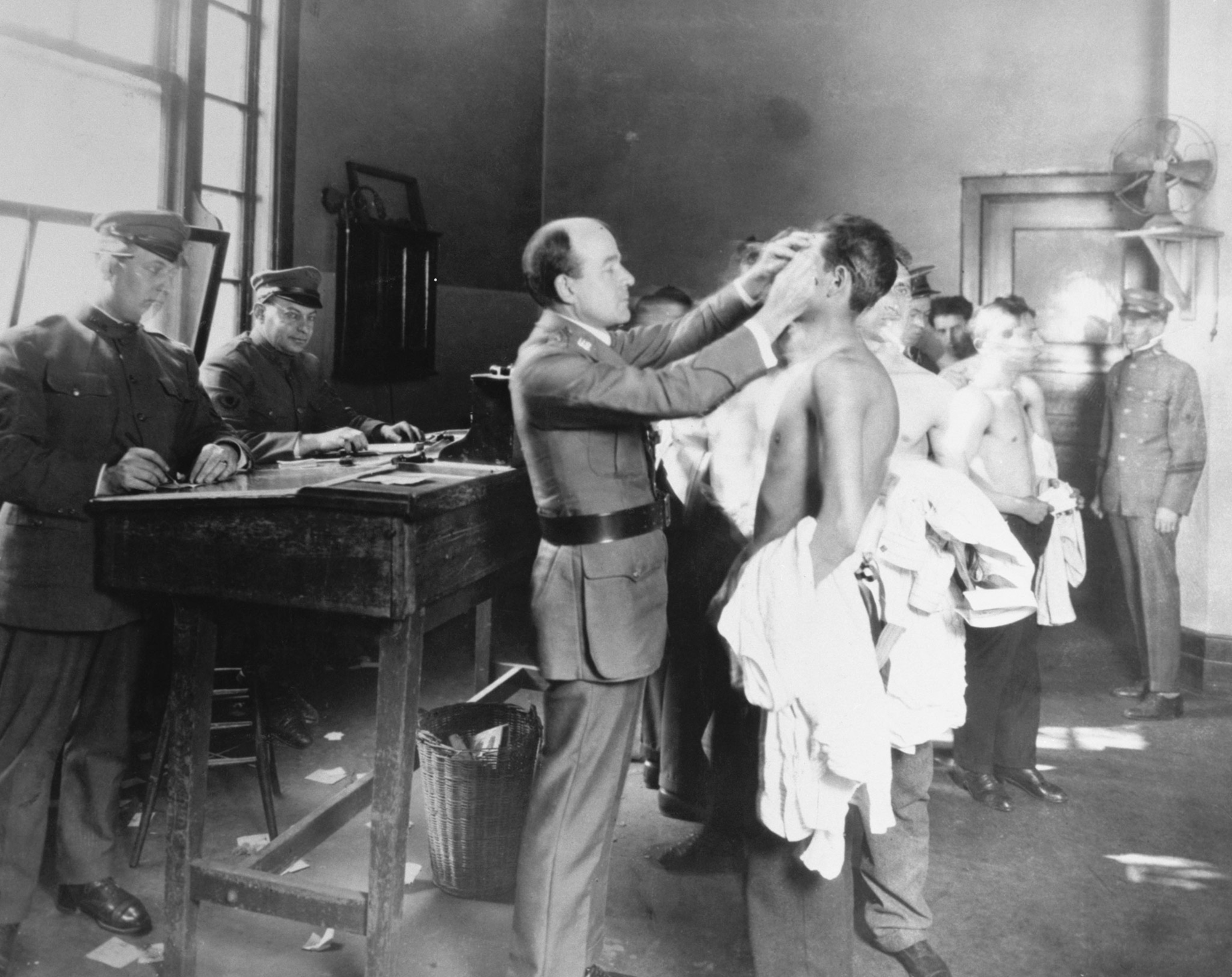 immigrants being checked by a doctor at Ellis Island New York