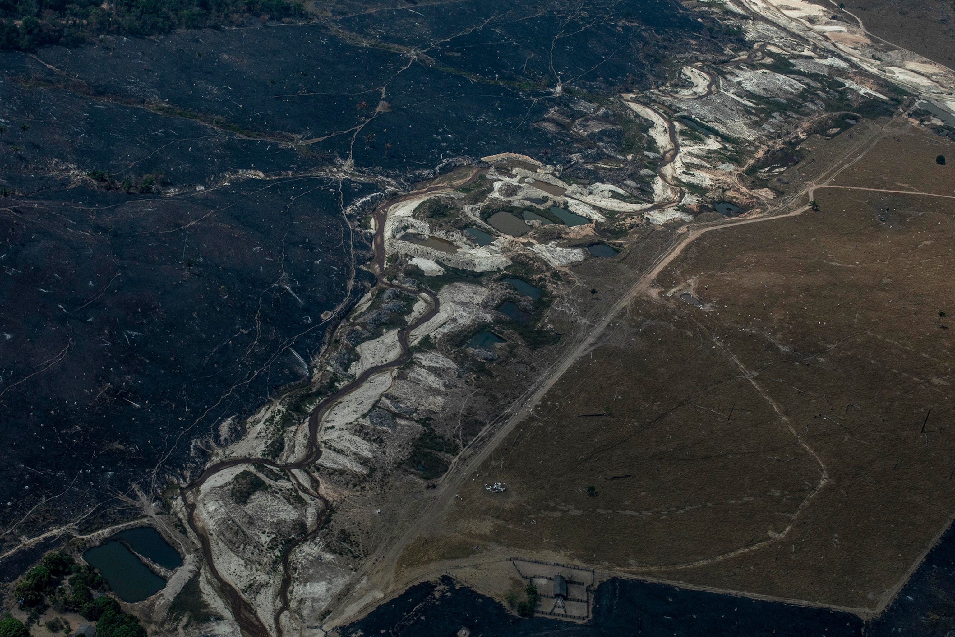 Picture of a farm area recently burned for livestock expansion and an abandoned gold mine