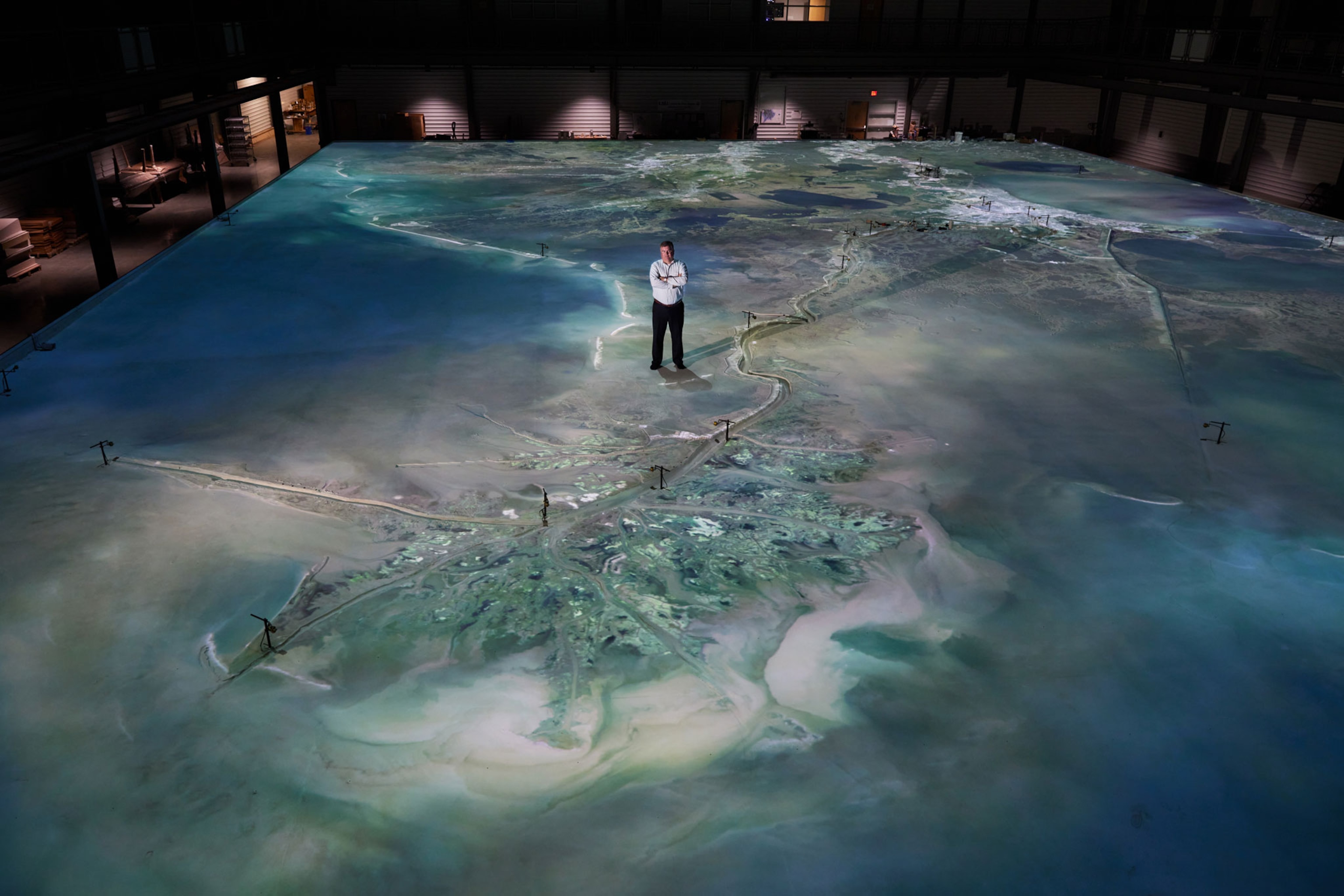 Bren Haase, director of Louisiana’s Coastal Protection and Restoration Authority stands on the 10,000 square foot model of the Mississippi River at the LSU Center for River Studies