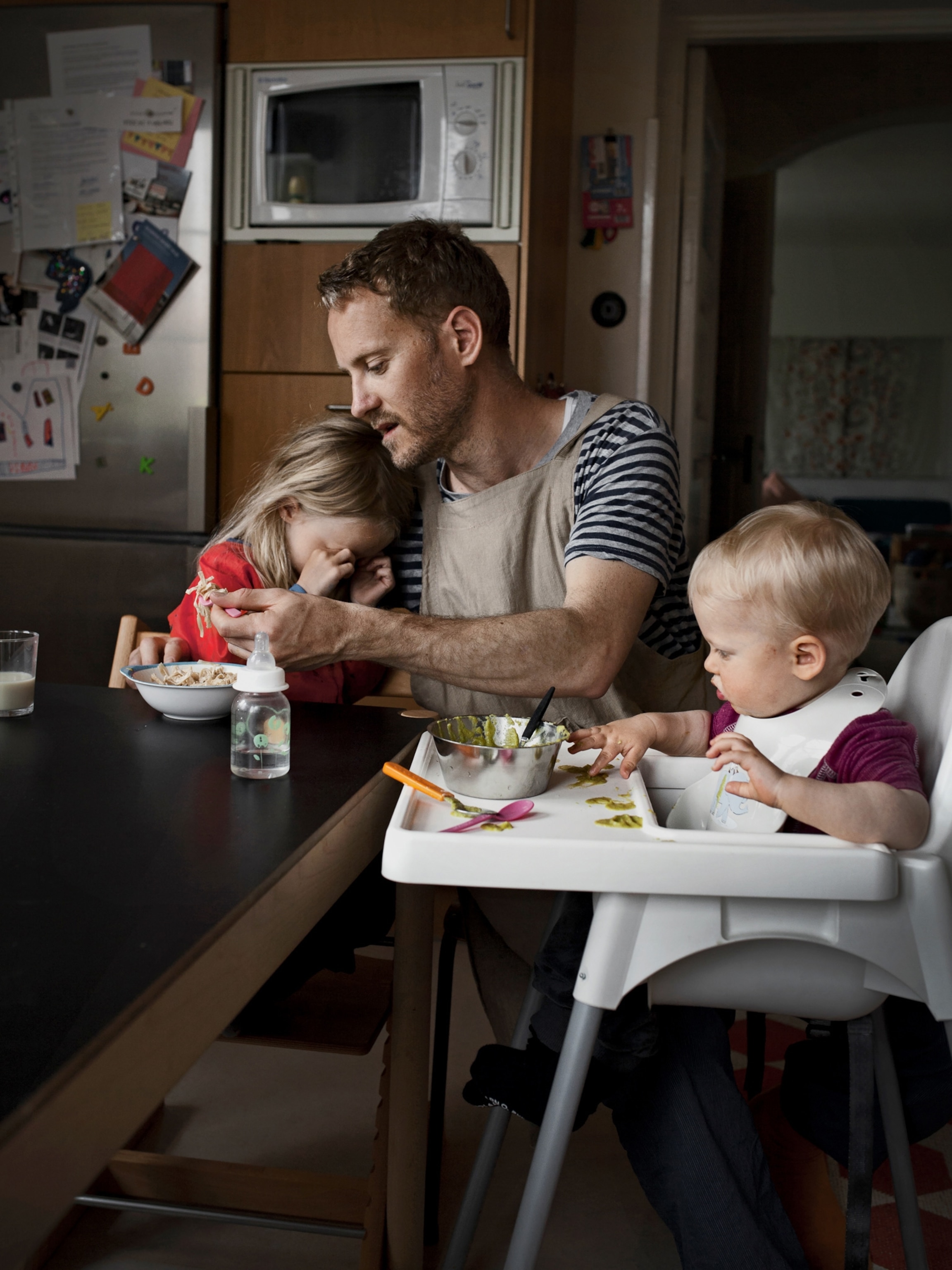 a father and his two children at mealtime
