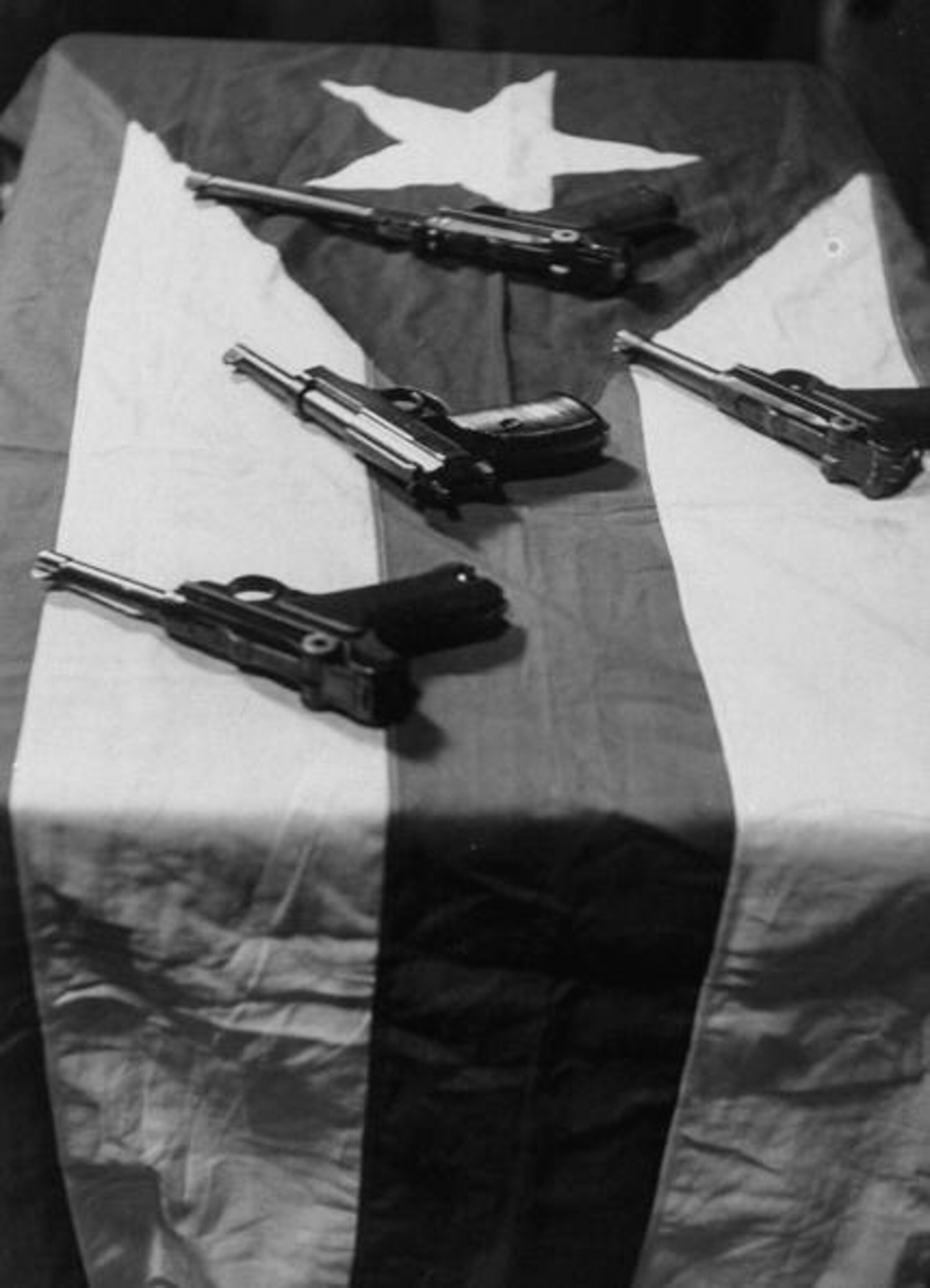 four guns sitting on a puerto rican flag