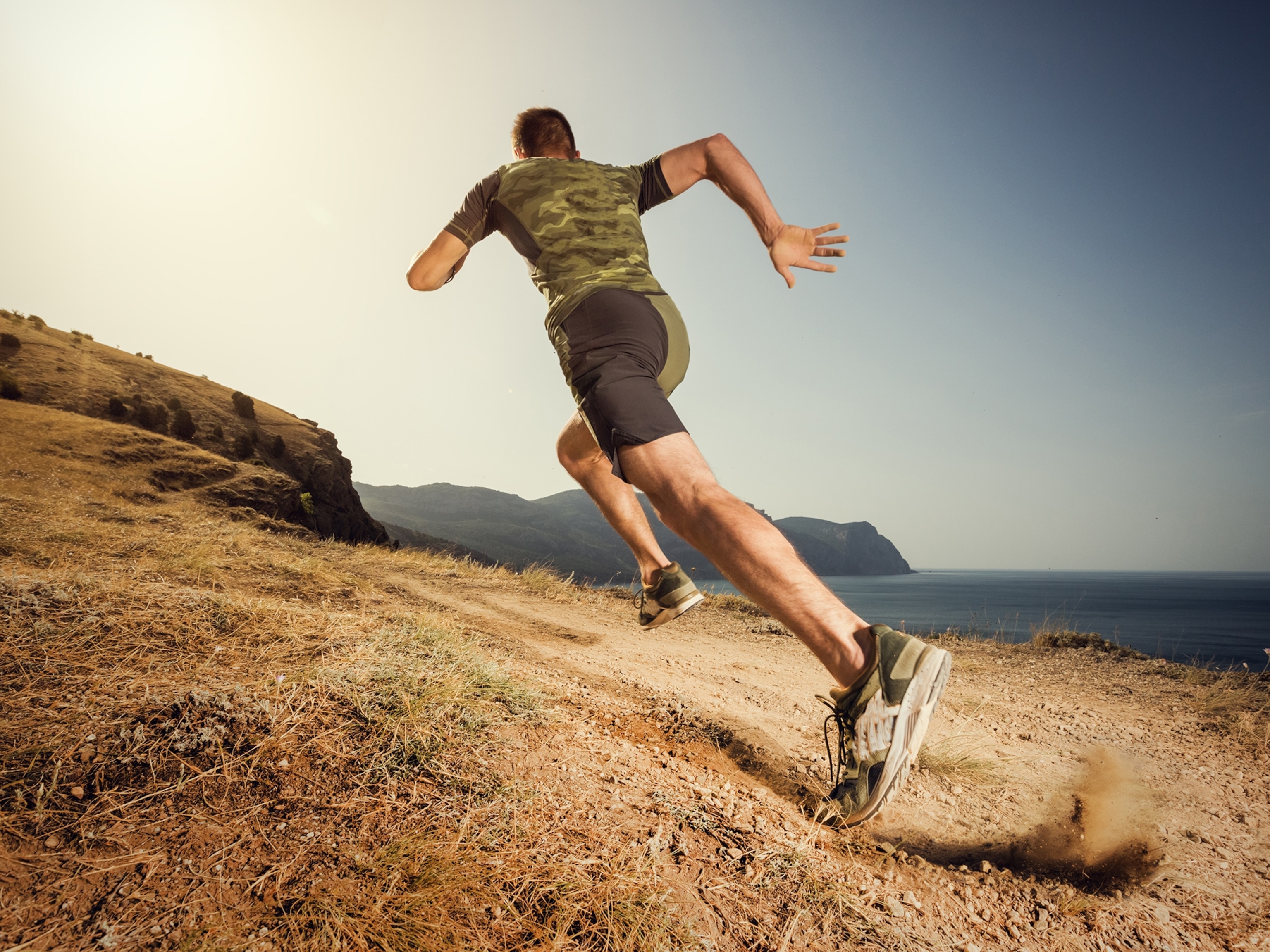 A man runs with vivid light on a dirt terrain.