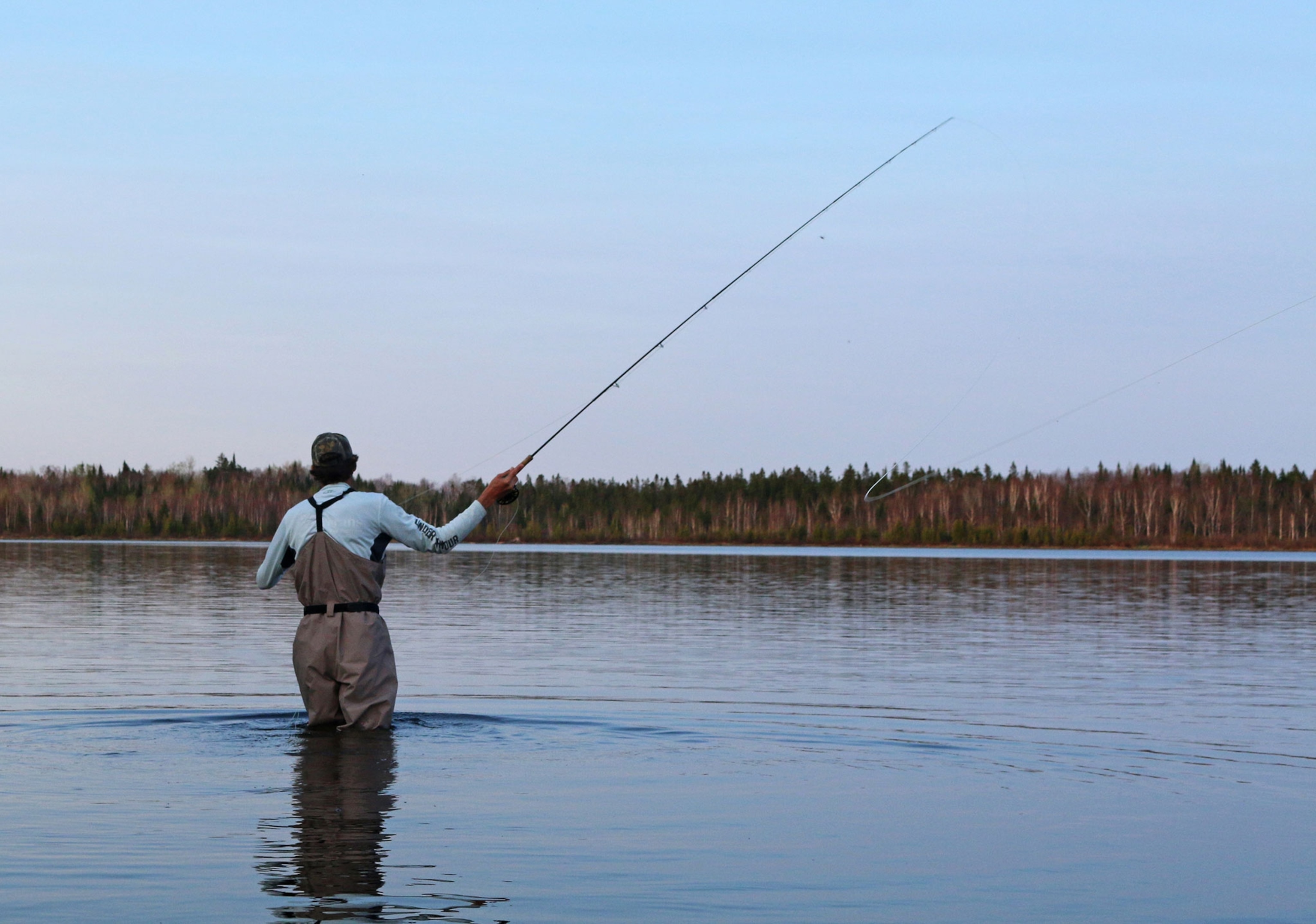 a fisherman casting a line in Maine