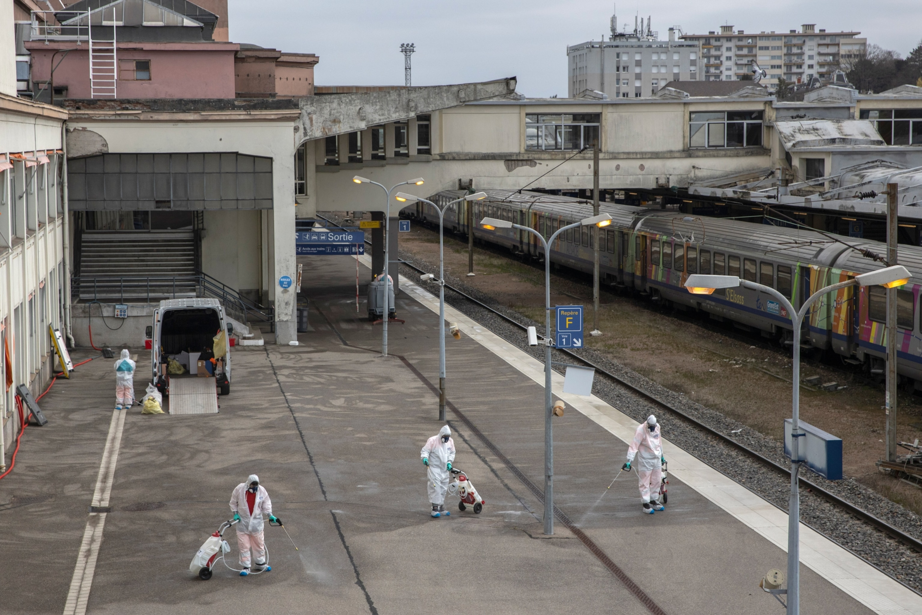 sanitation workers cleaning a outdoor train platform