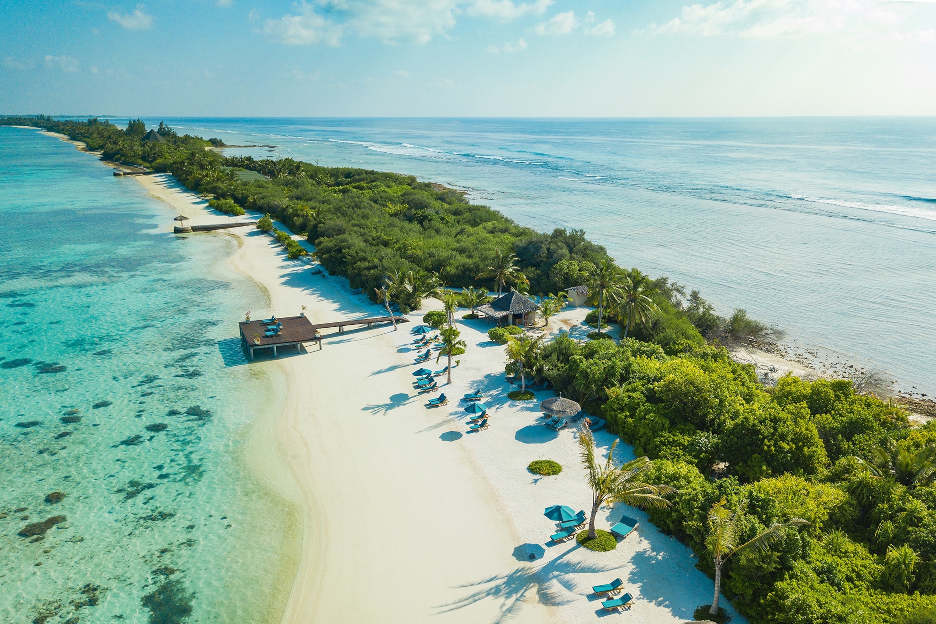 Aerial view of a resort in the maldives with white sands and turquoise sea