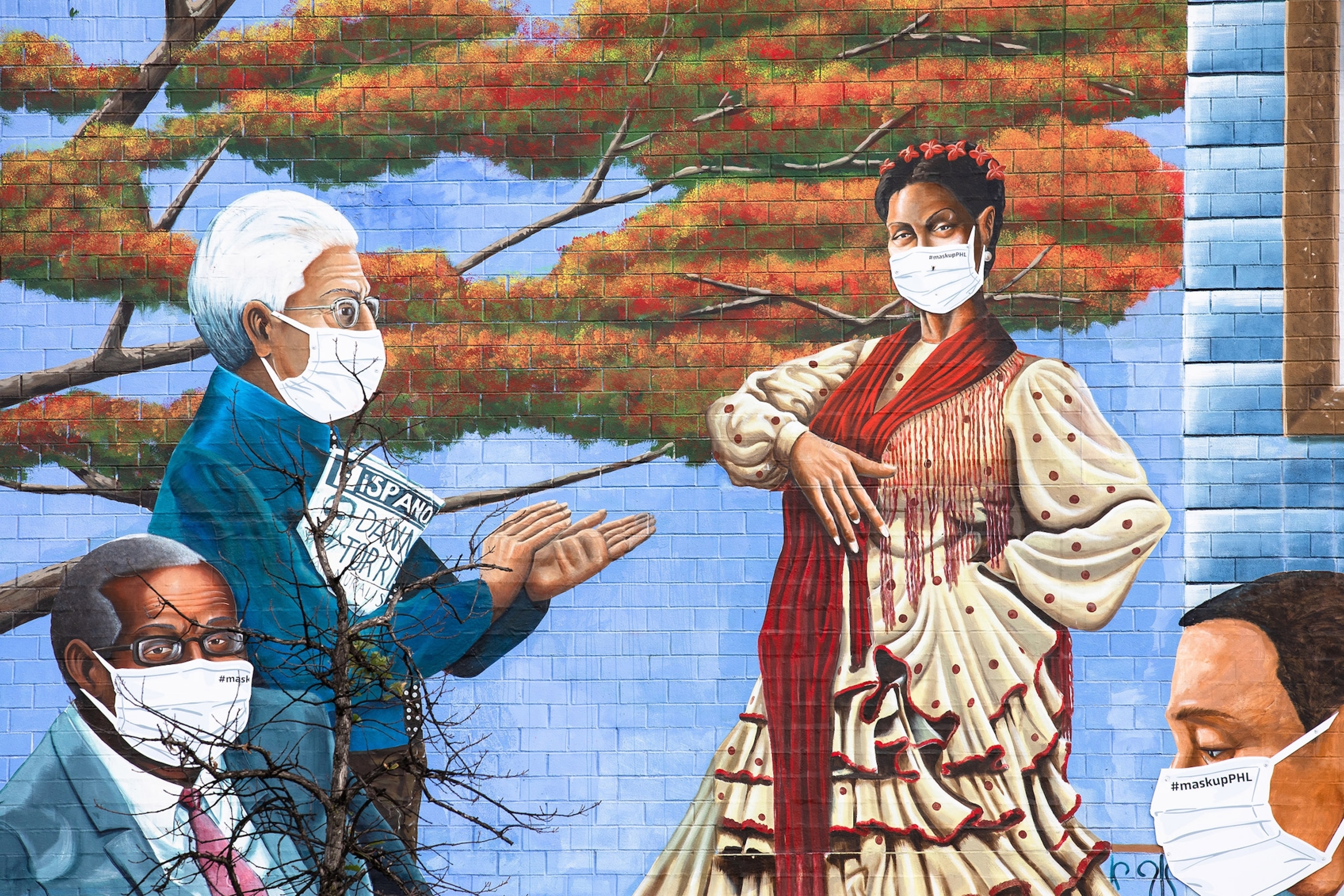 The “Latinx Heroes” mural at Julia De Burgos Elementary School in Fairhill has been temporarily updated with masks on the people in the mural