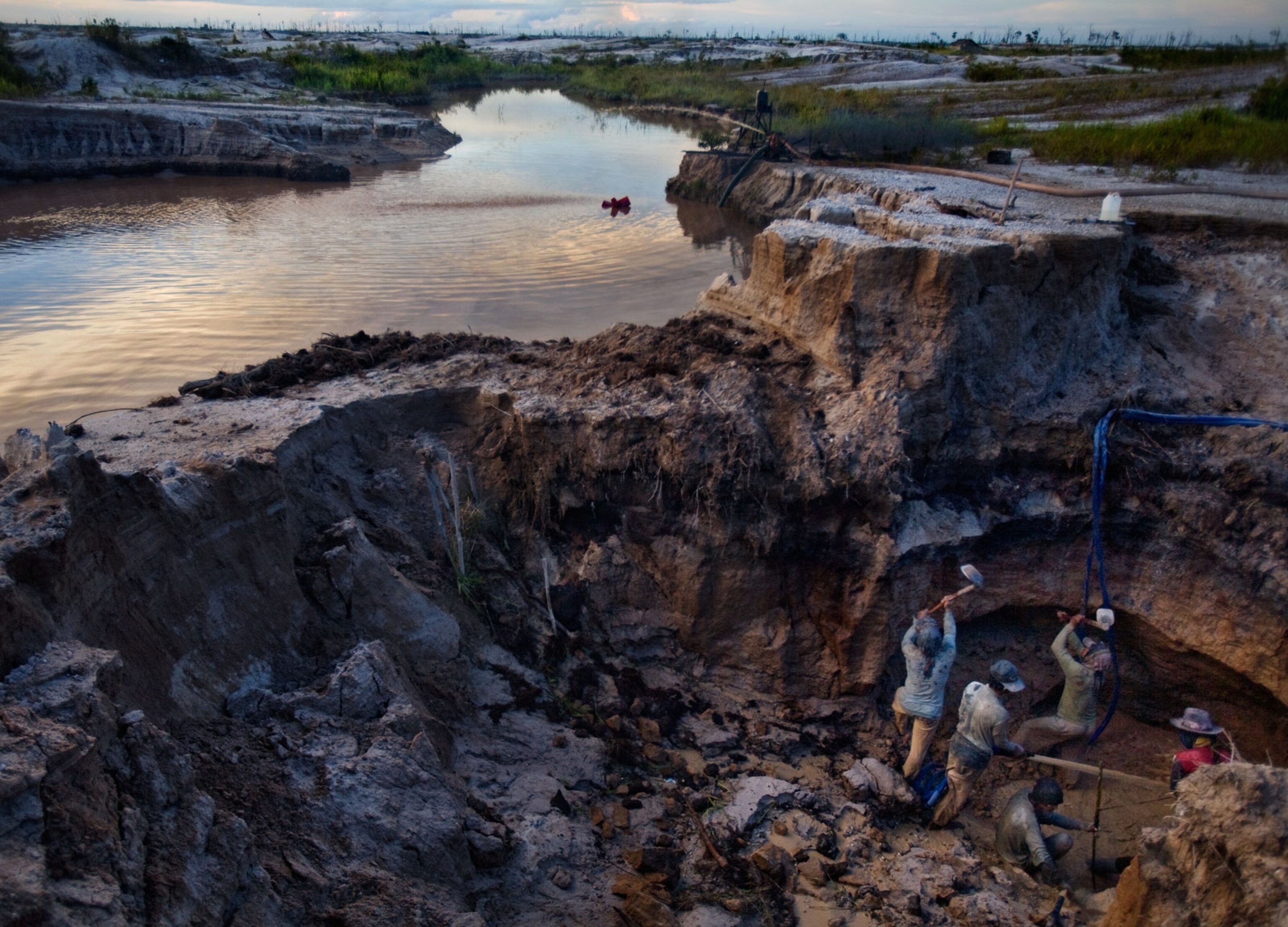 Indonesian farmers illegally digging for gold on a torn up riverbank in Borneo