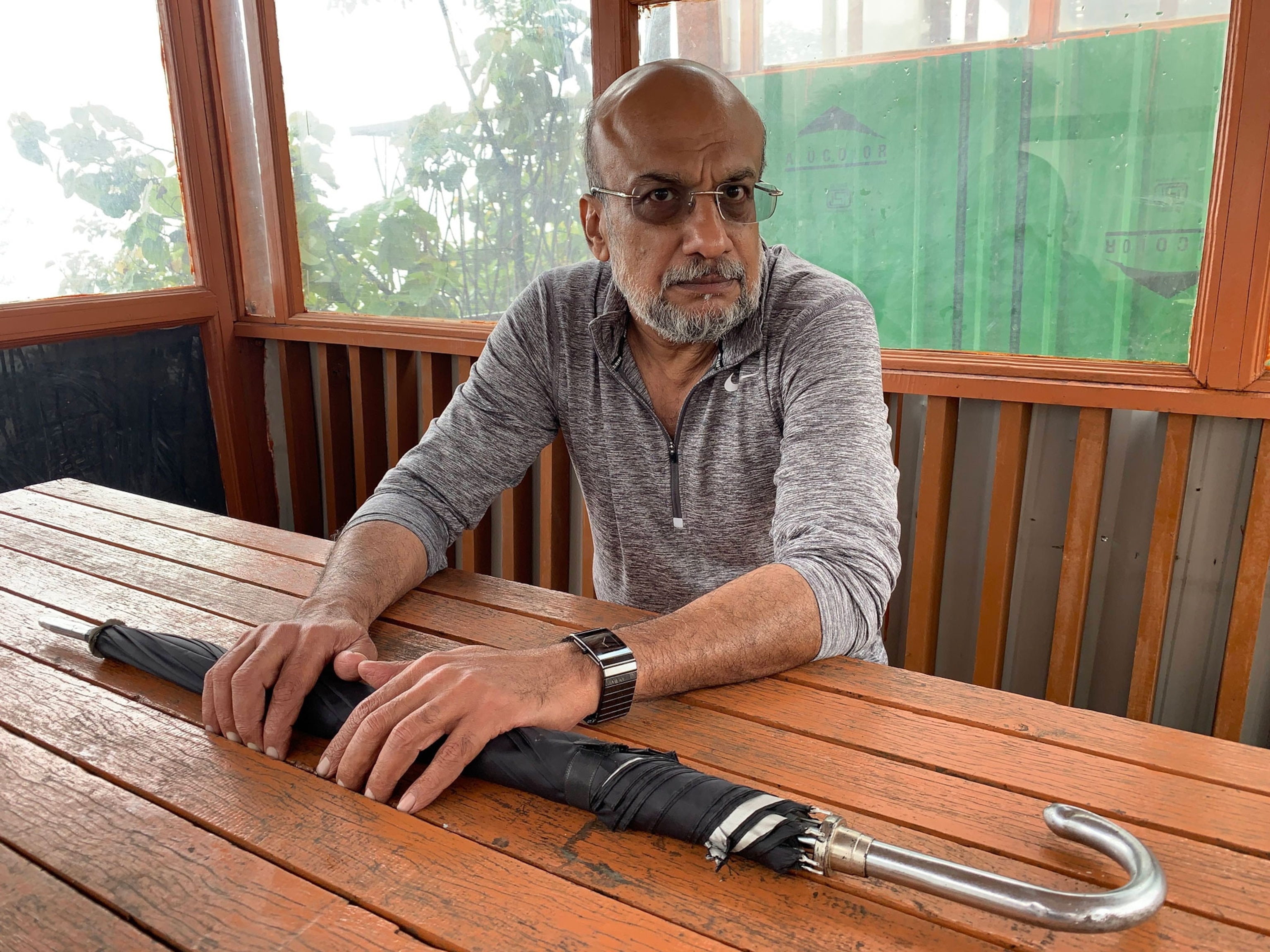a man seated with an umbrella.