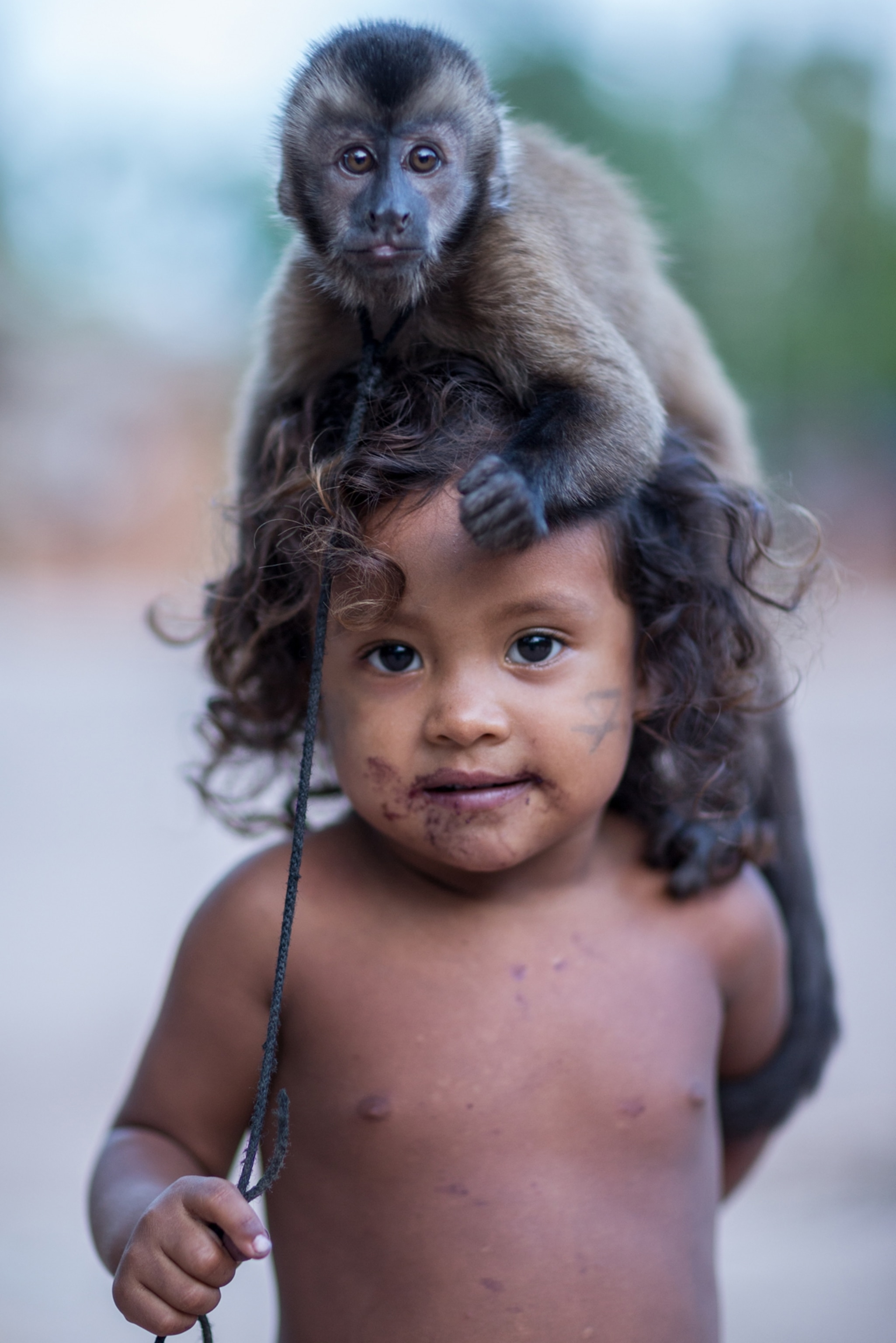 a young child with a monkey on her head