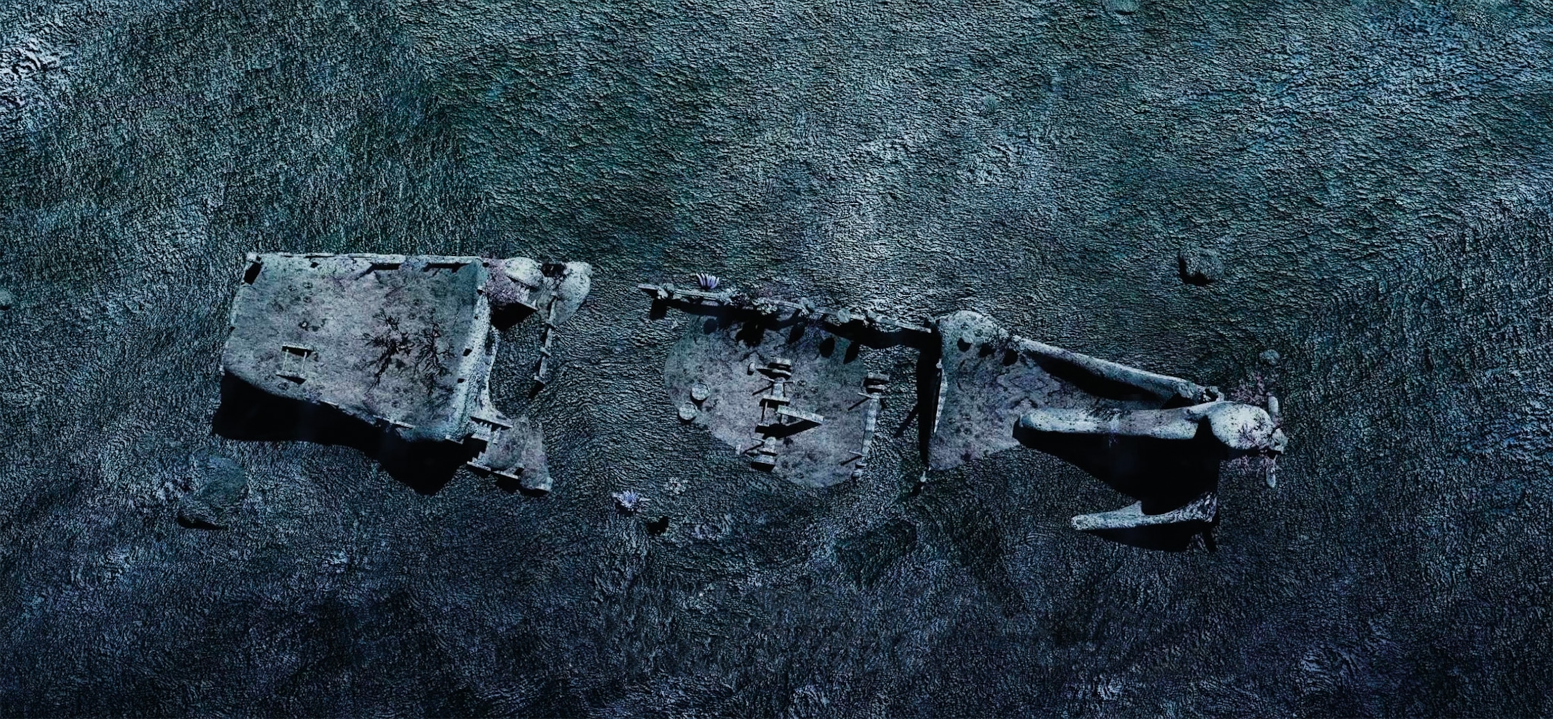 an aerial view of a sunken boat in the ocean.