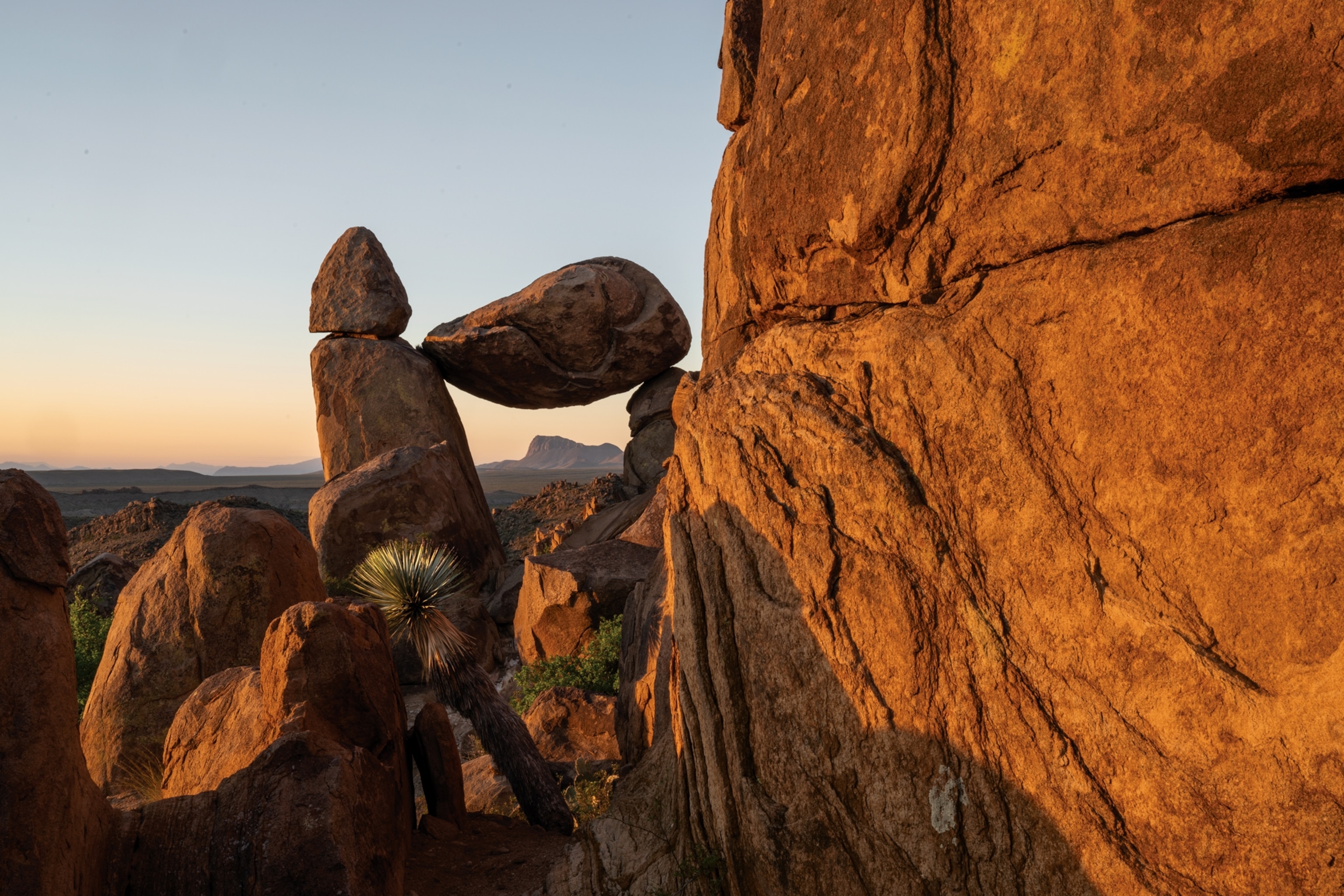 Picture of large rock balancing atop of other two standing vertically.
