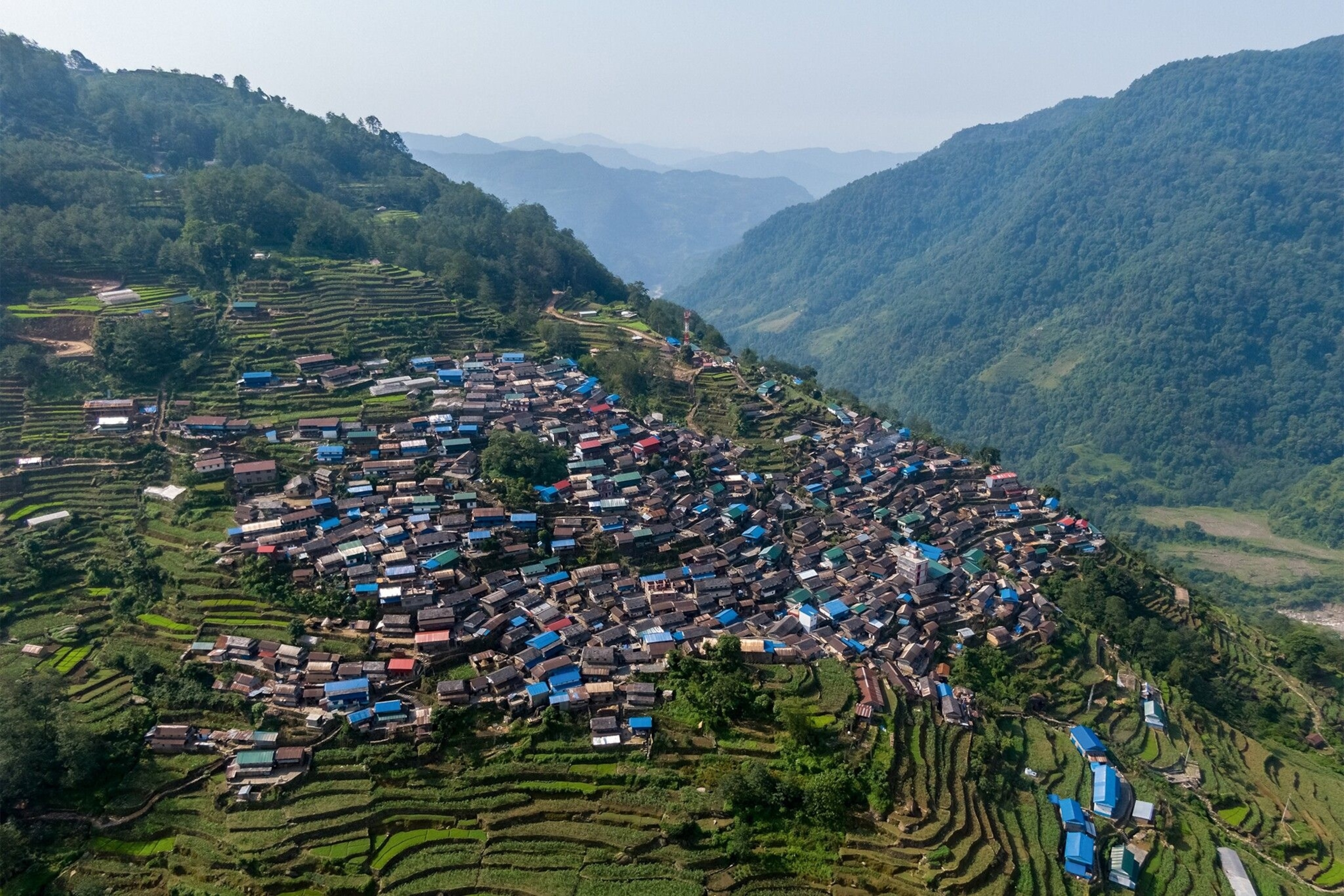 Lush valley, surrounded on all sides by emerald mountains, with around 800 houses , packed densely together
