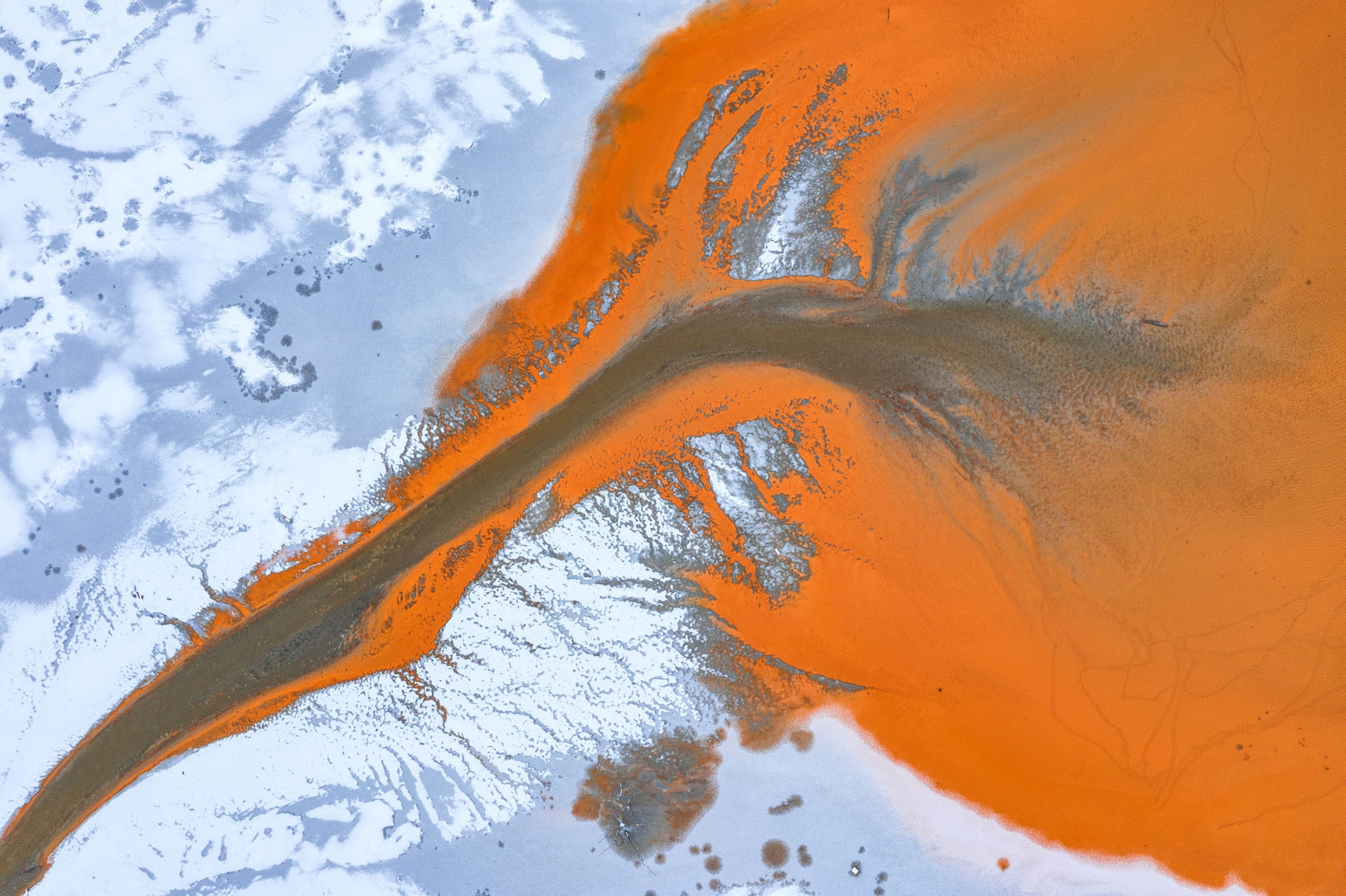 Picture of like web of abstract shapes created by the chemical residues mixed with the freshly fallen snow.