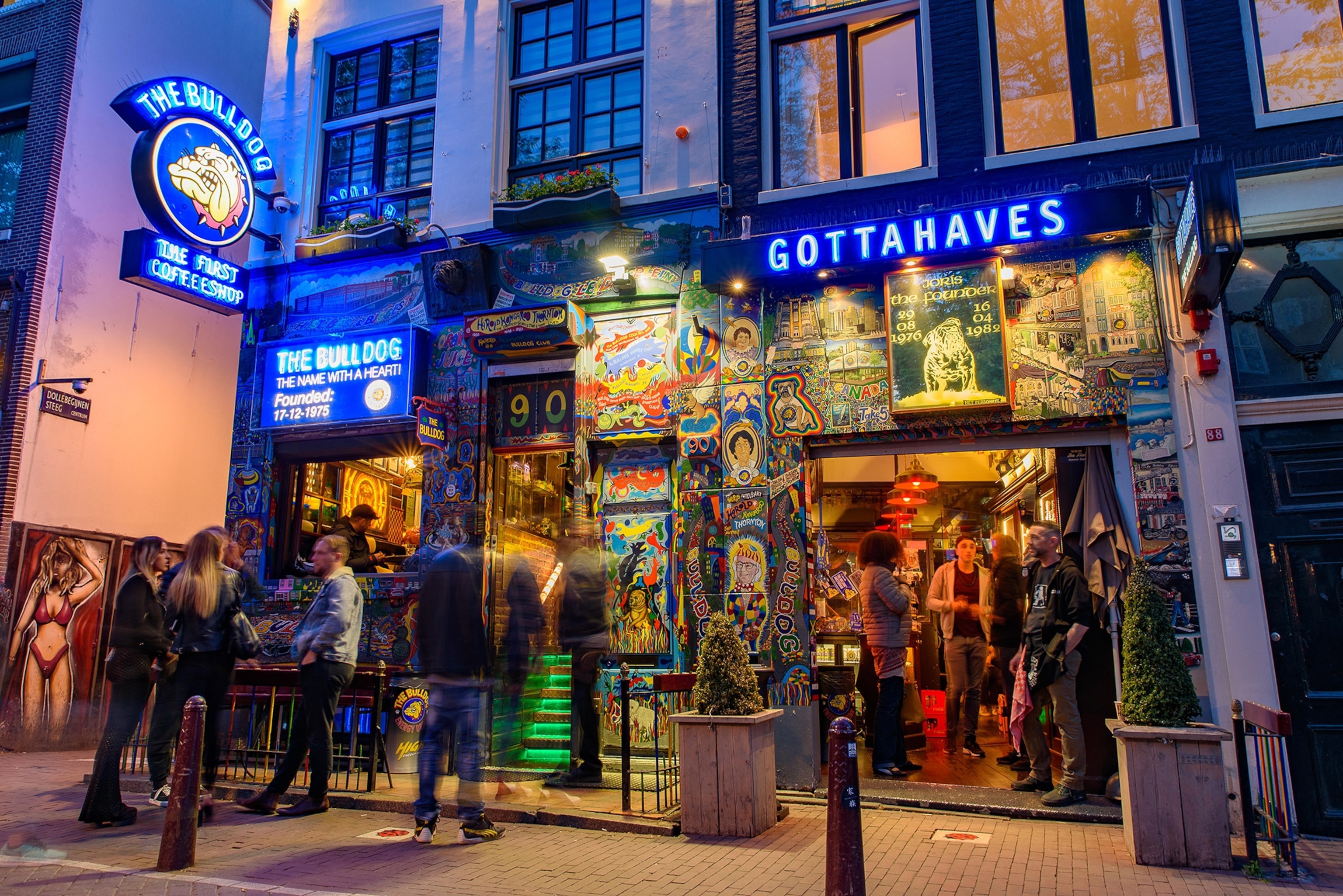 People walk in and out fo shop with blue neon lights.