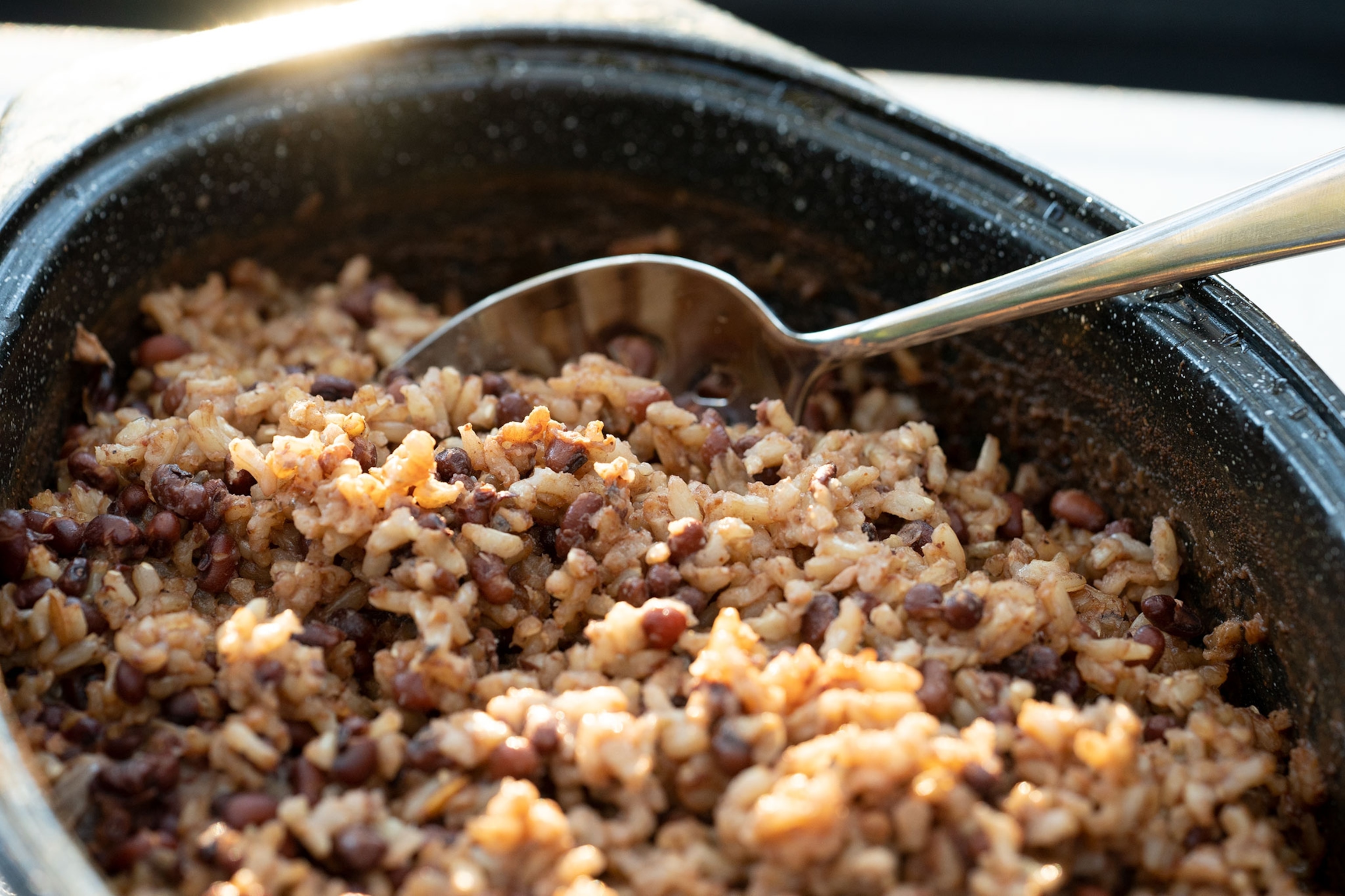 A spoon rests in a pot of Hoppin’ John With Carolina gold rice and Sapelo red peas
