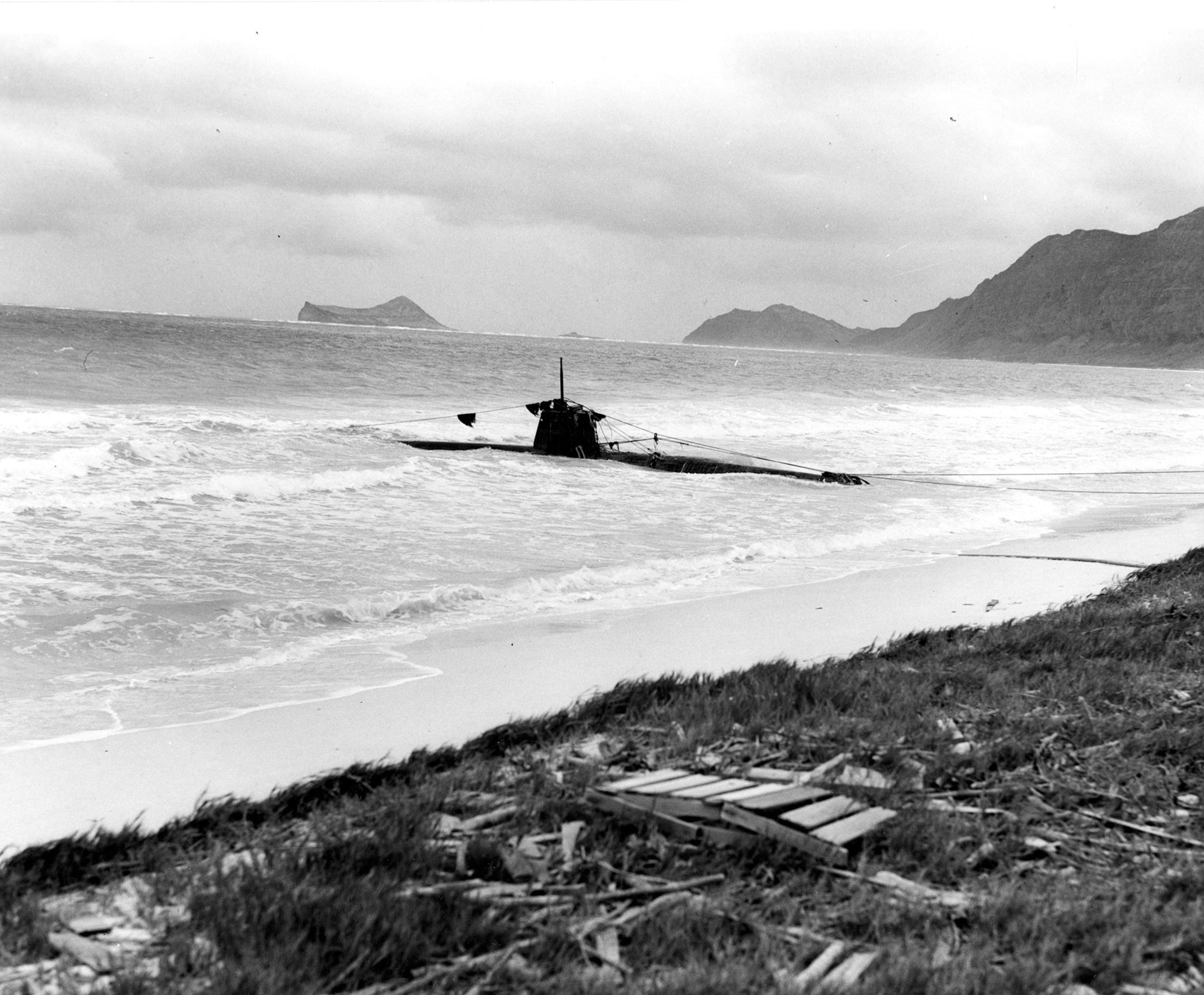 a black and white photo of a submarine beached in Oahu, Hawaii