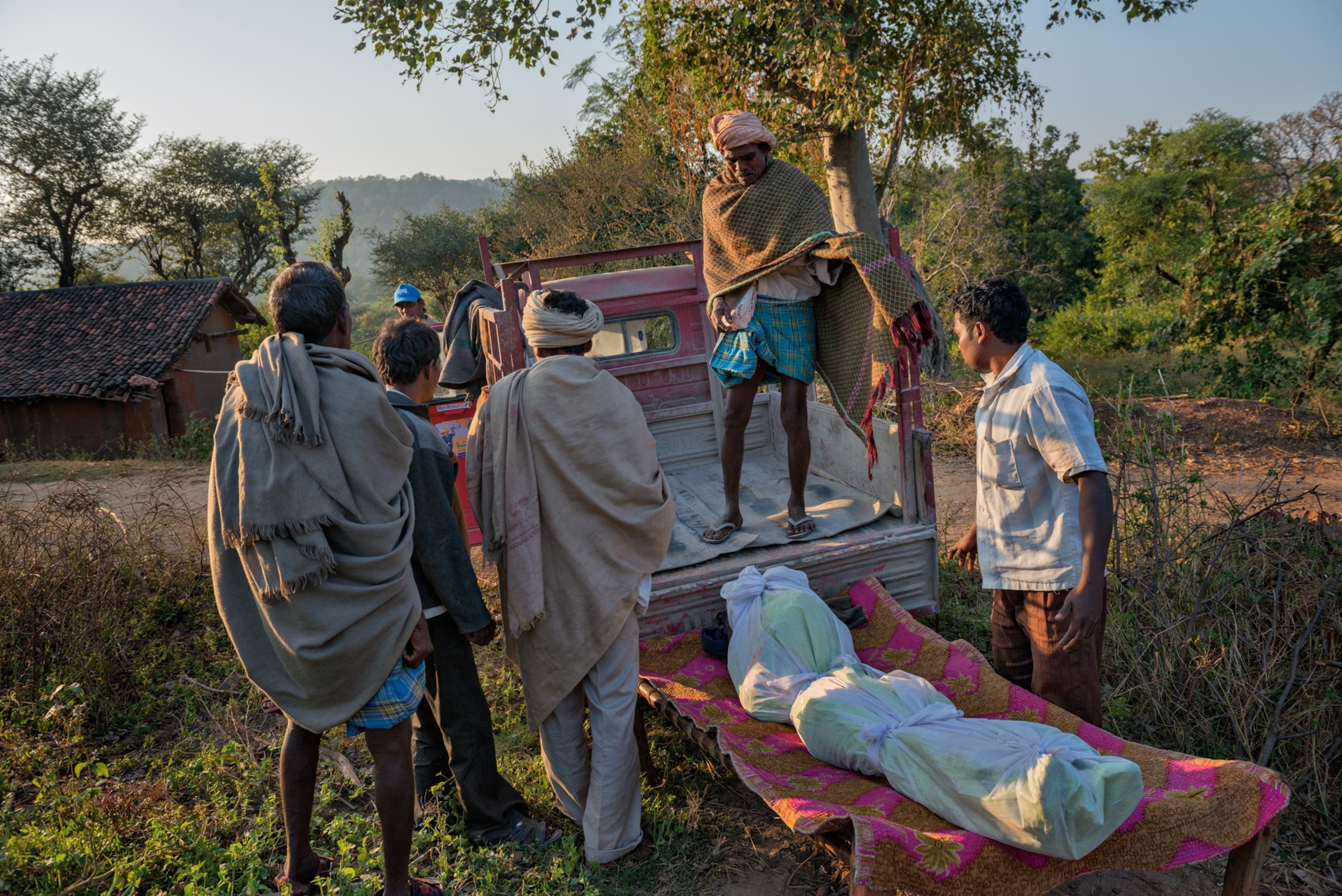 a man collecting his son's body in the village of Heso in Jharkhand