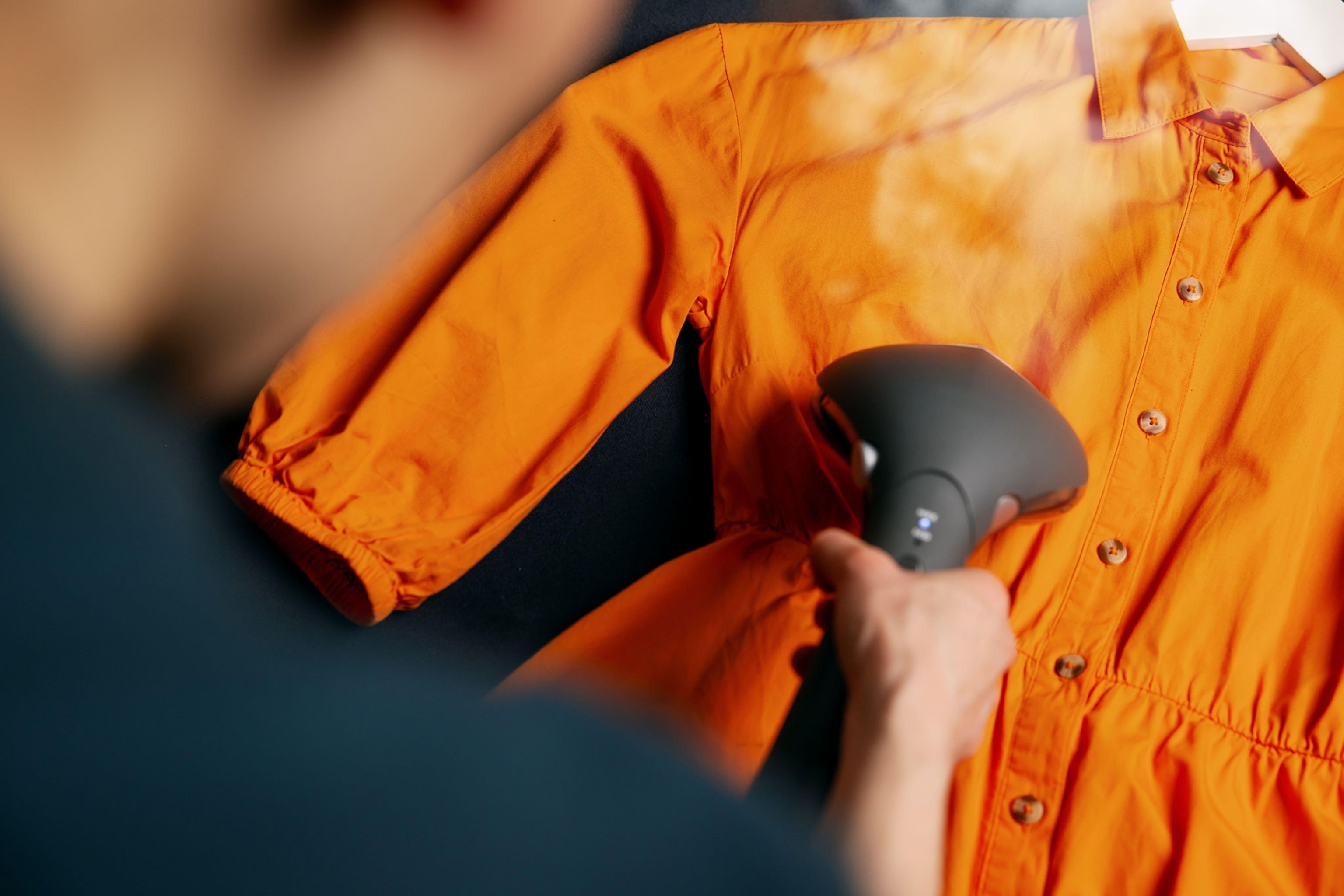 Person steaming bright orange dress.