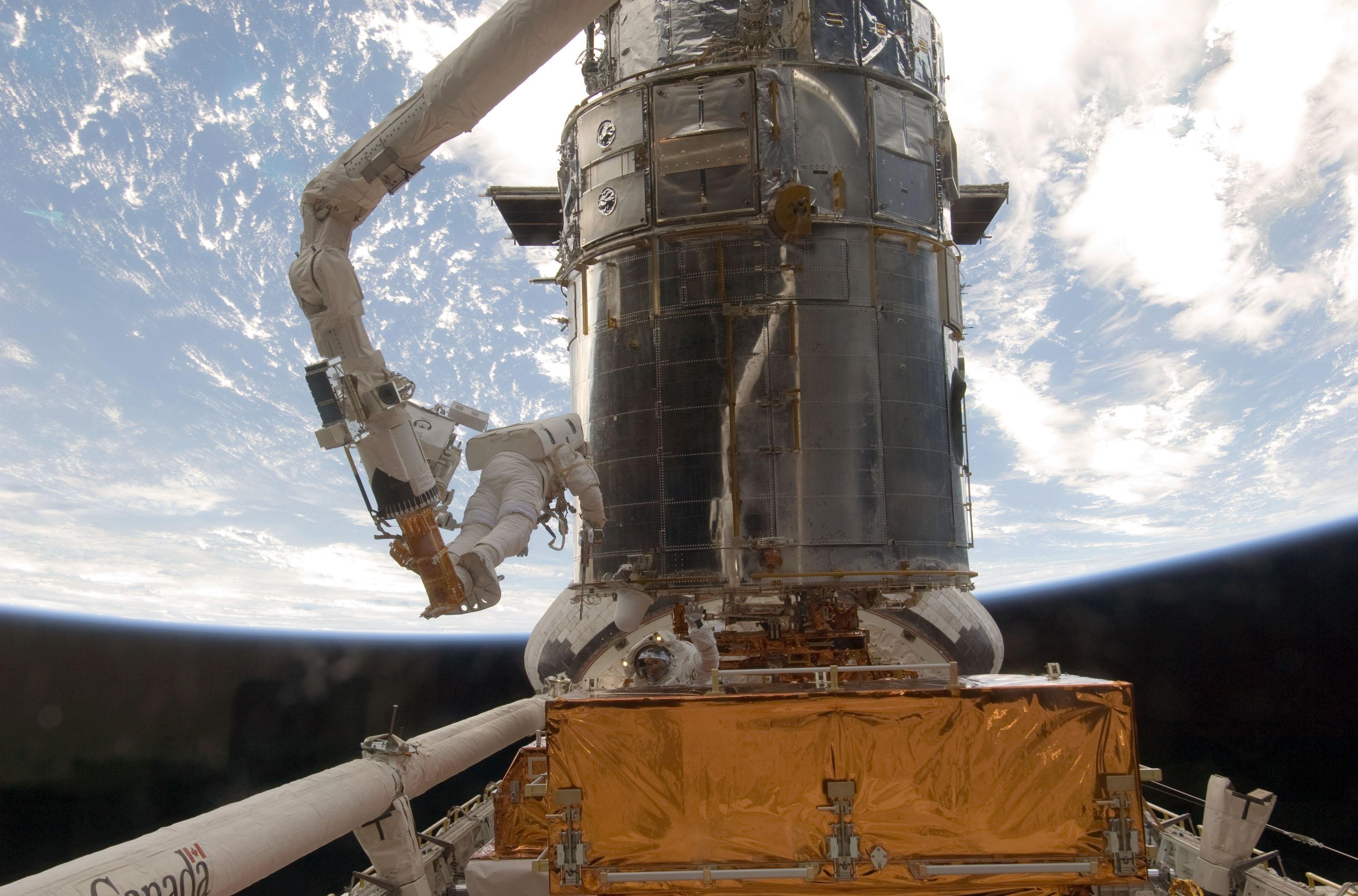 astronaut John Grunsfeld on a space walk to repair the Hubble telescope
