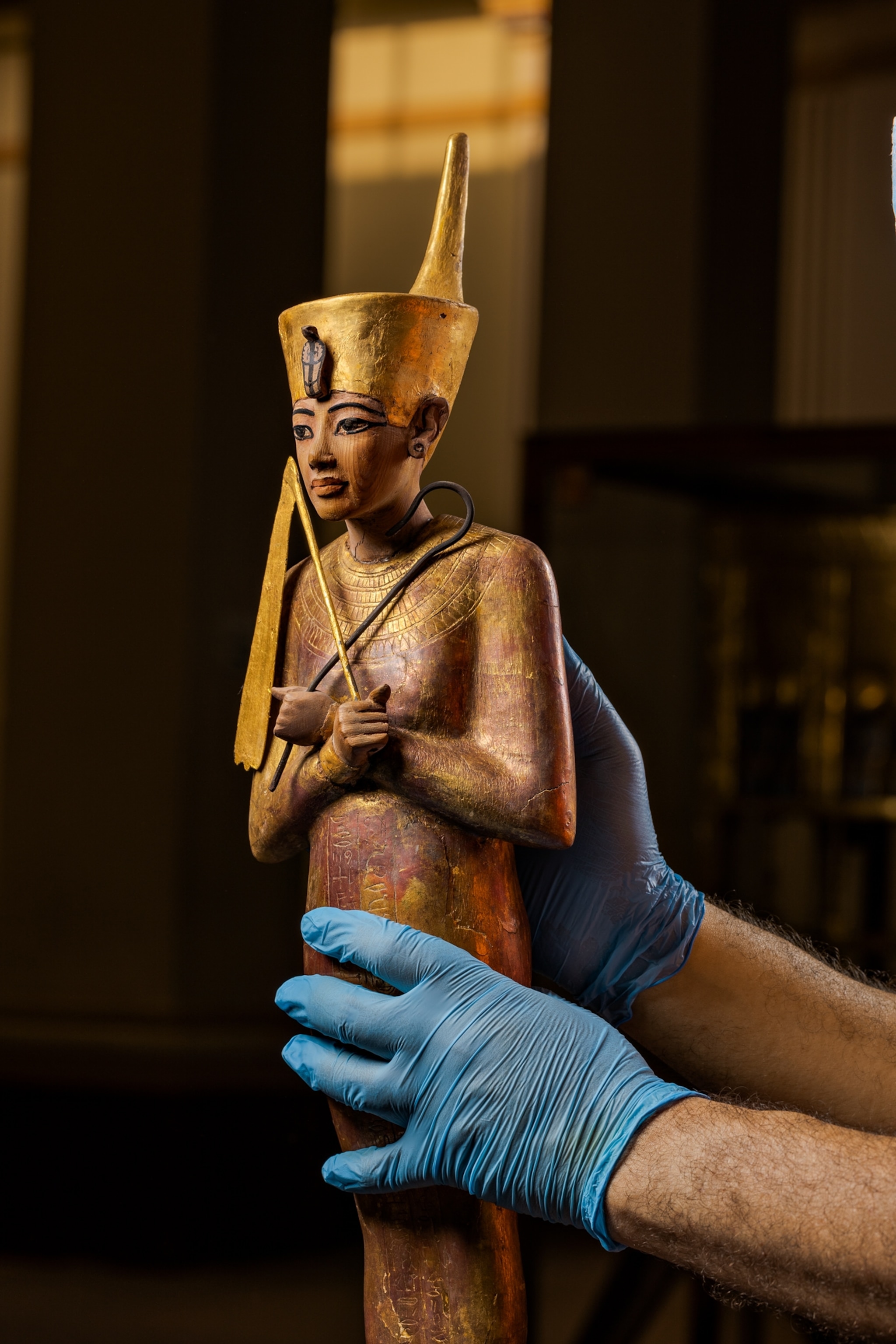Hands holding a small figurine, one of Tut's treasures.