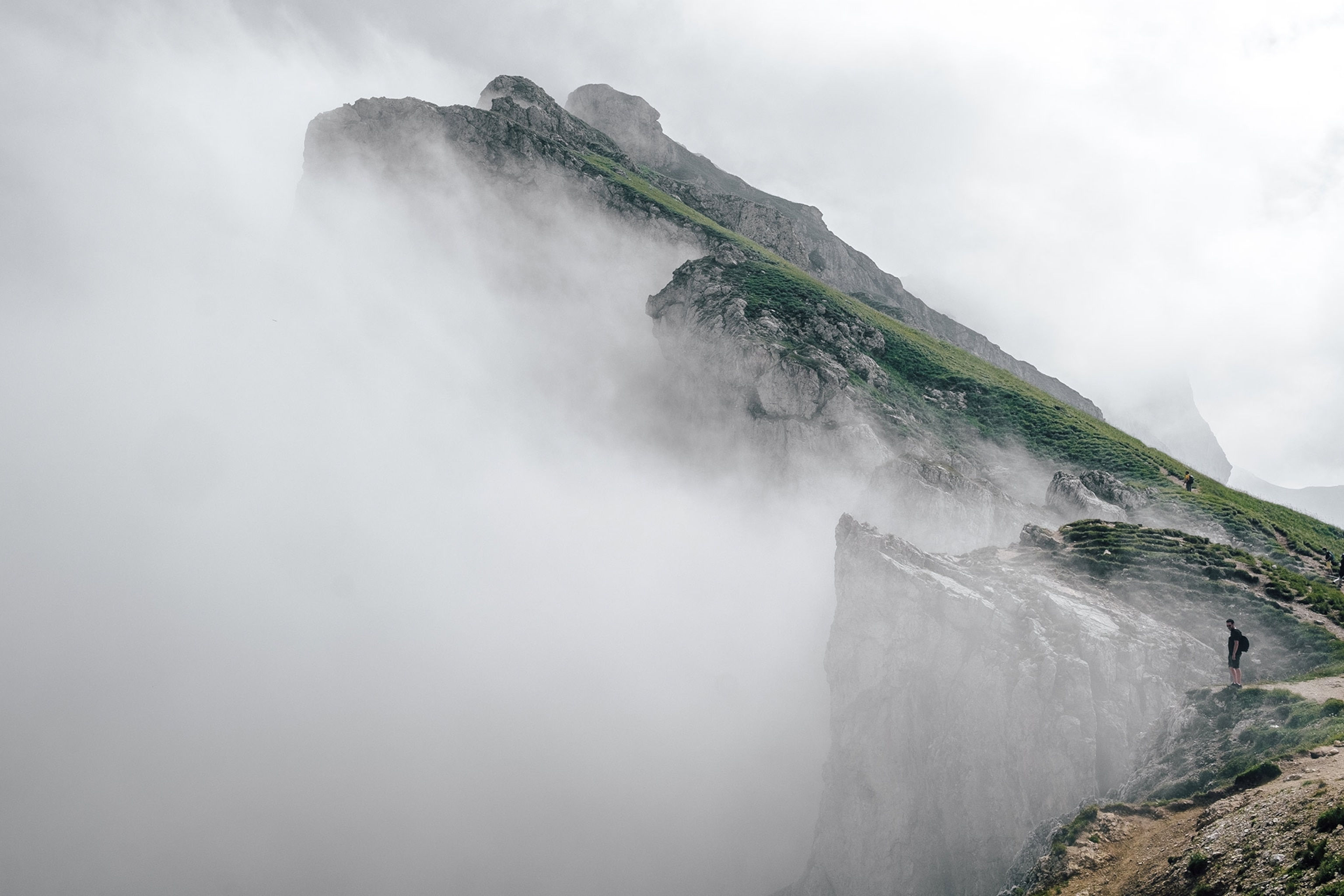 a hiker standing in fog, South Tyrol, Italy