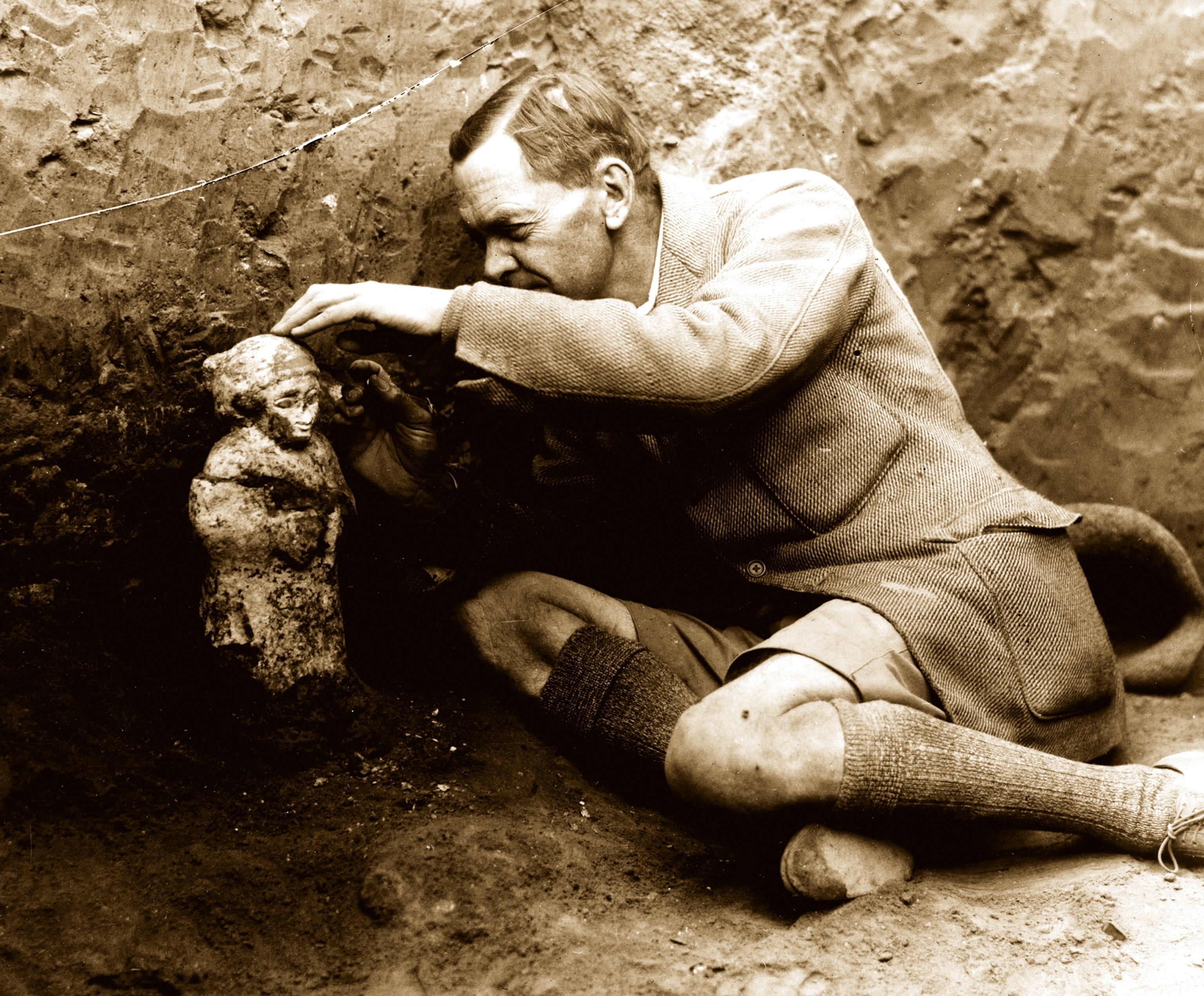 Leonard Woolley removing the earth from a votive figurine at Ur