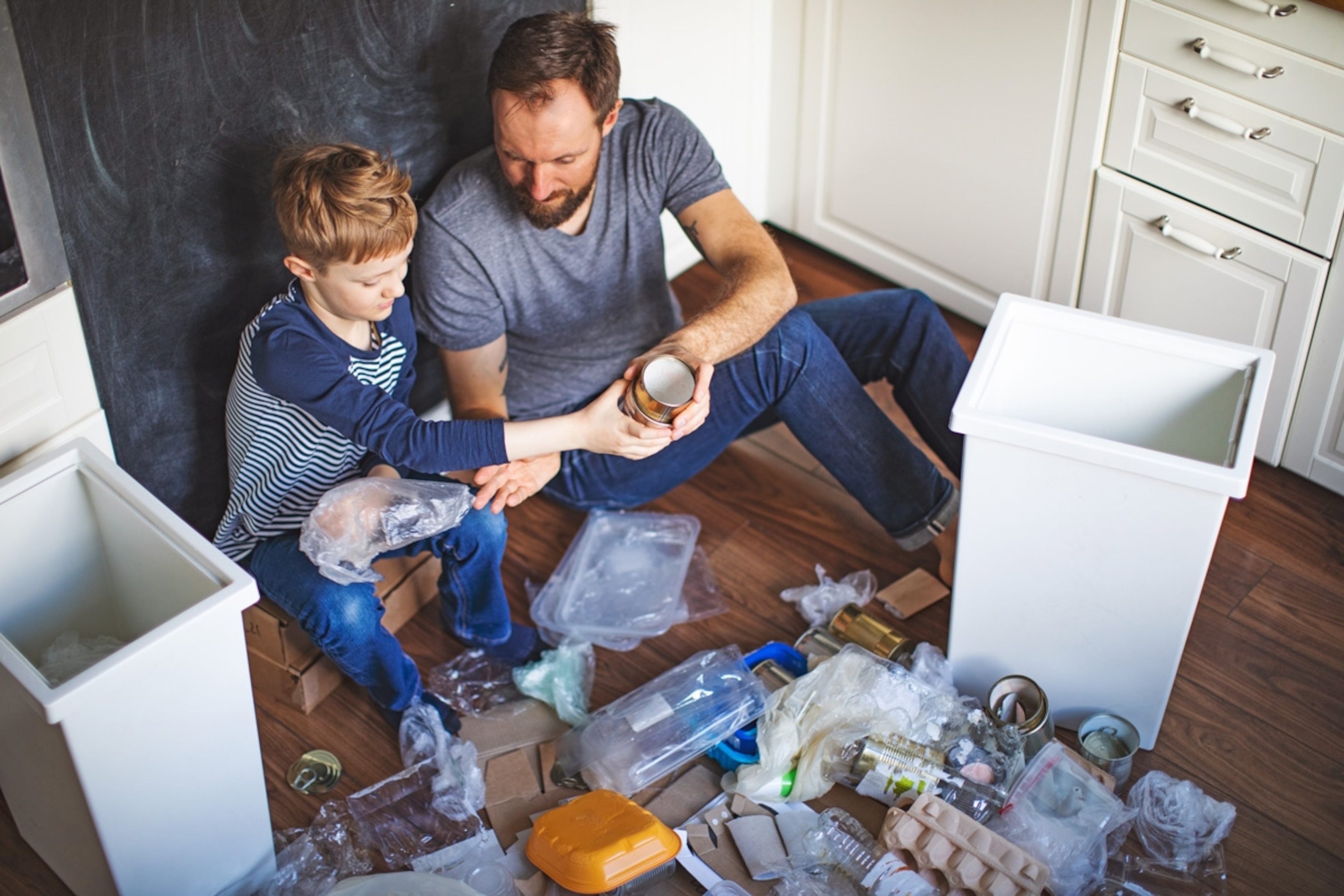 Father and son sorting waste at home.