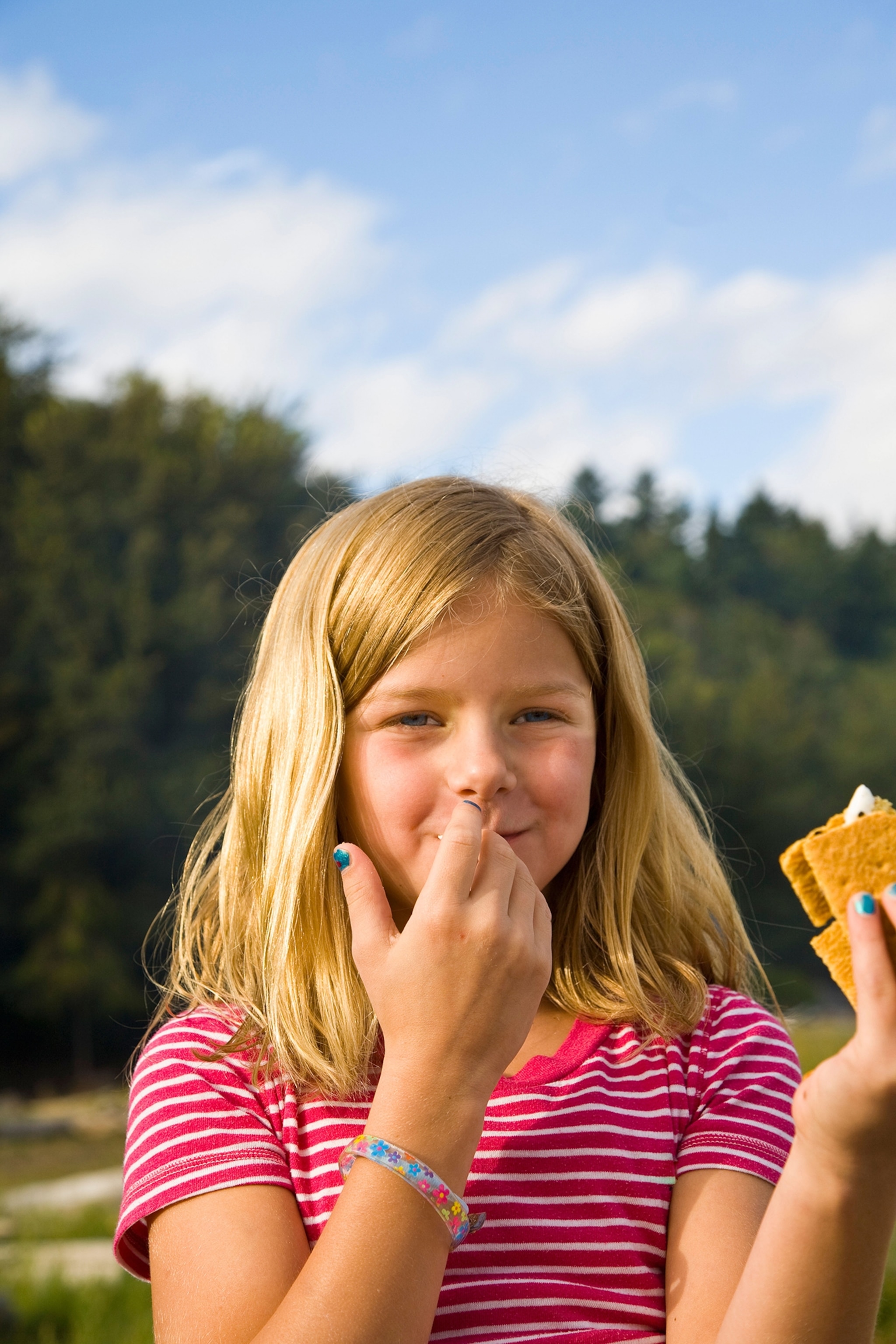 girl eating s'more outdoors