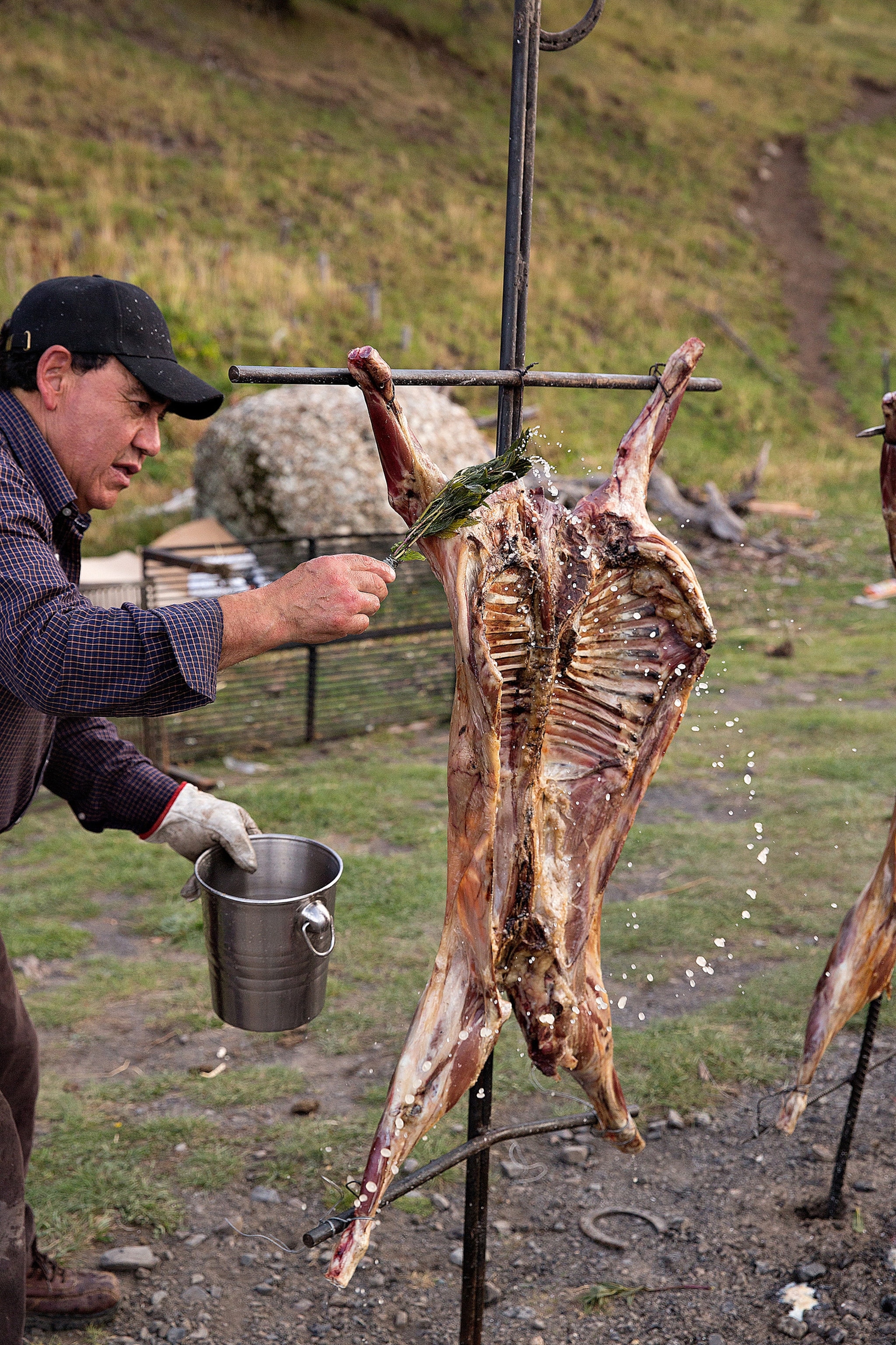 a man roasting a lamb in Torres del Paine, Patagonia, Chile