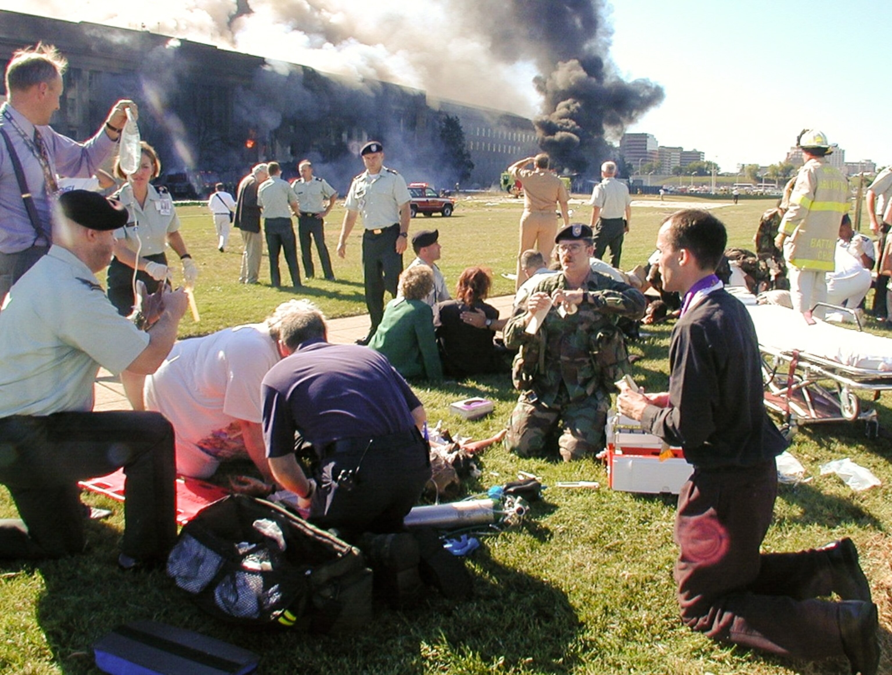 9/11 picture: people helping a wounded man outside of the Pentagon
