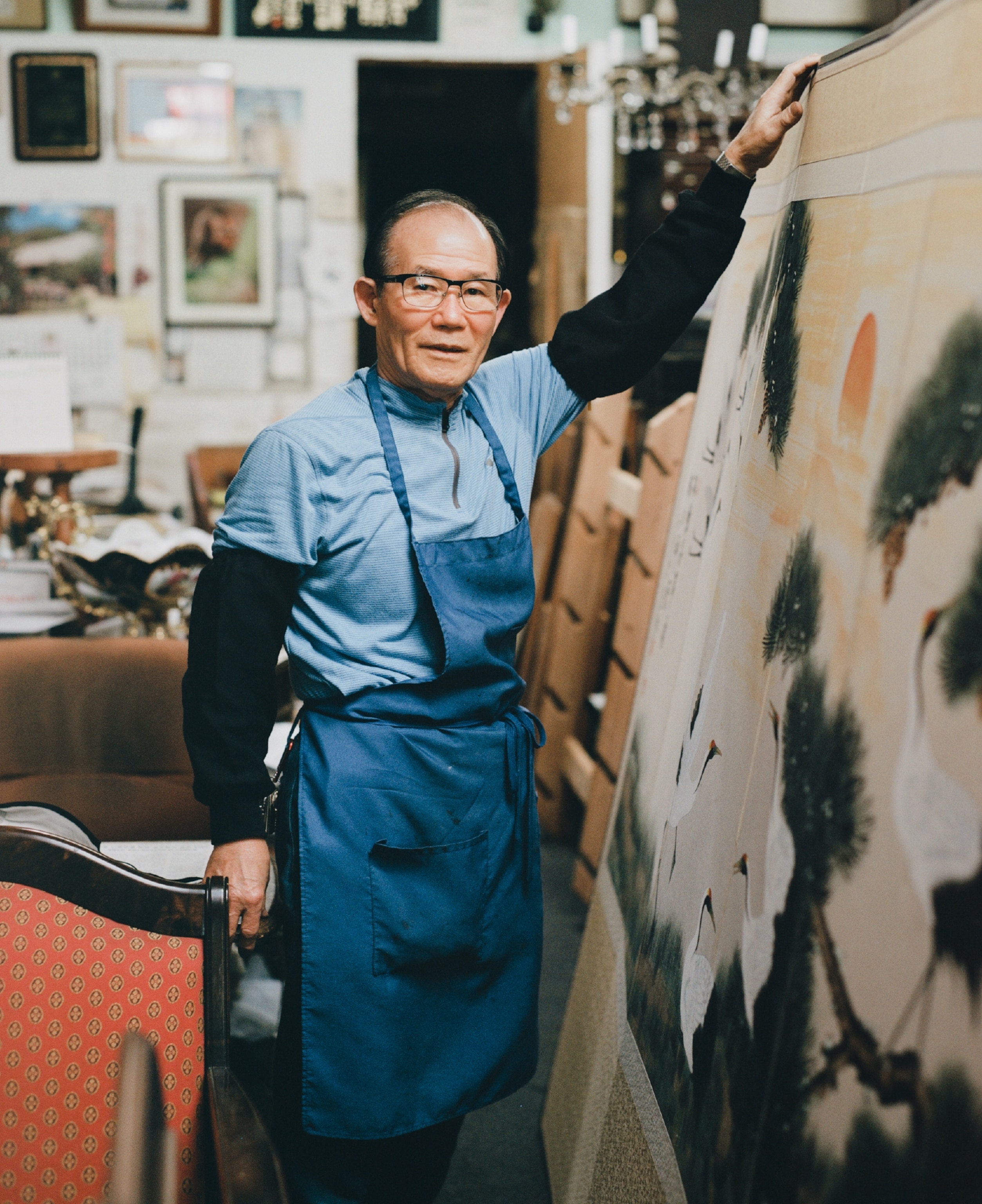 Man stands with his antique furniture and artwork