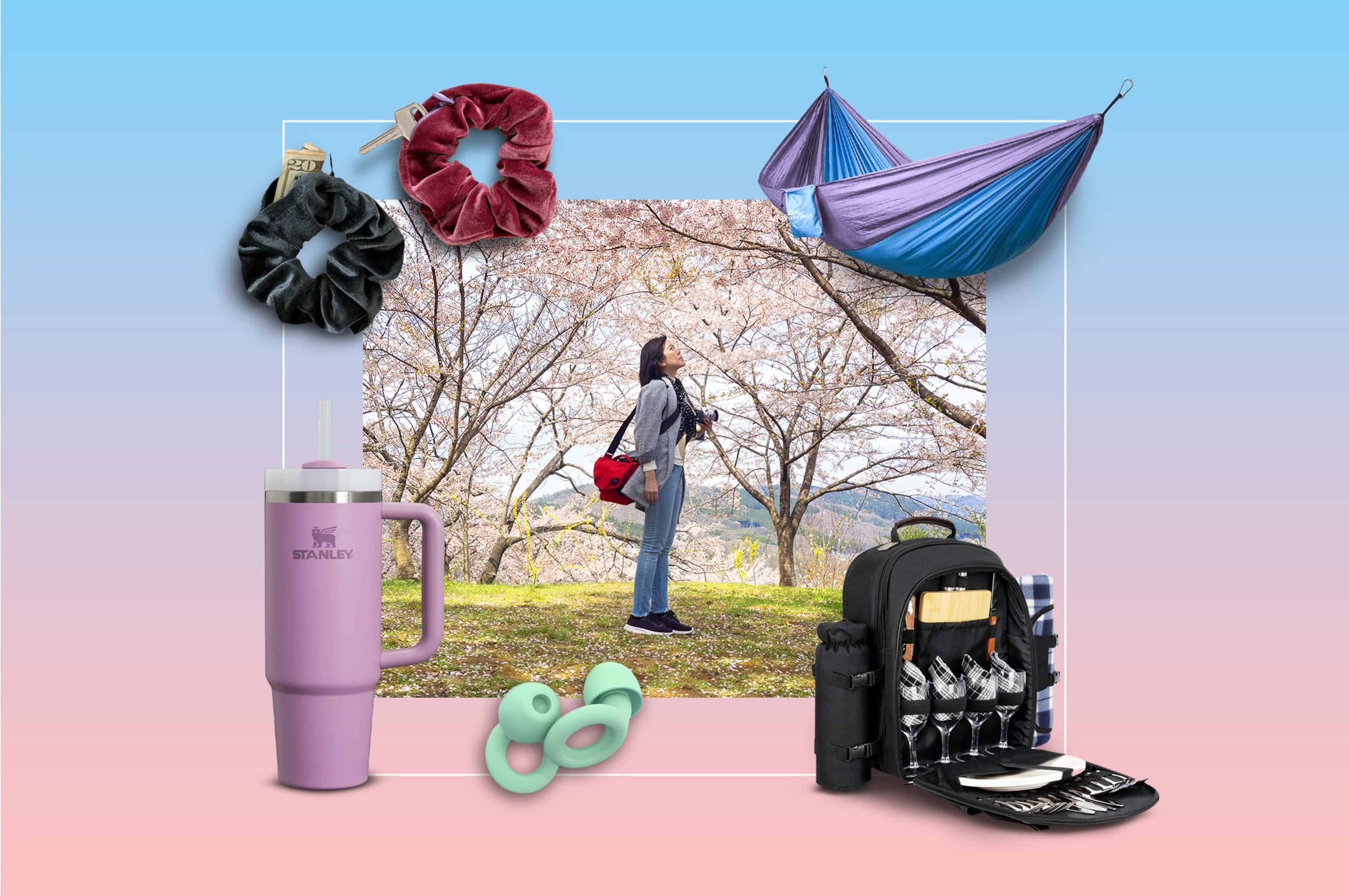 A women holds a camera while looking at cherry blossoms.