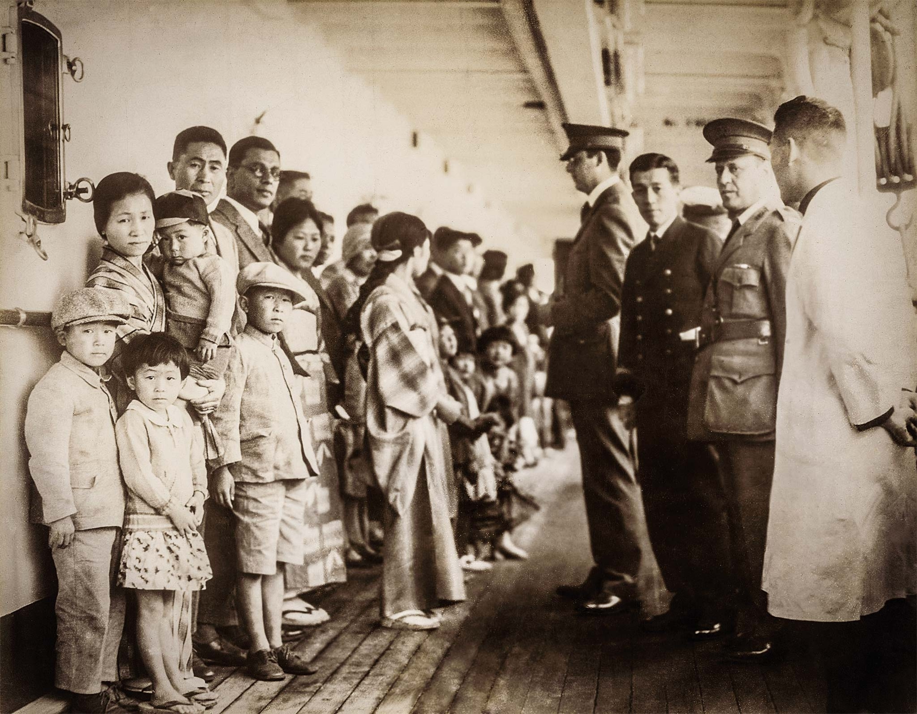 Before disembarking, Japanese passengers on their way to Angel Island are examined by U.S. officials aboard the ship Shimyo Maru around 1931.