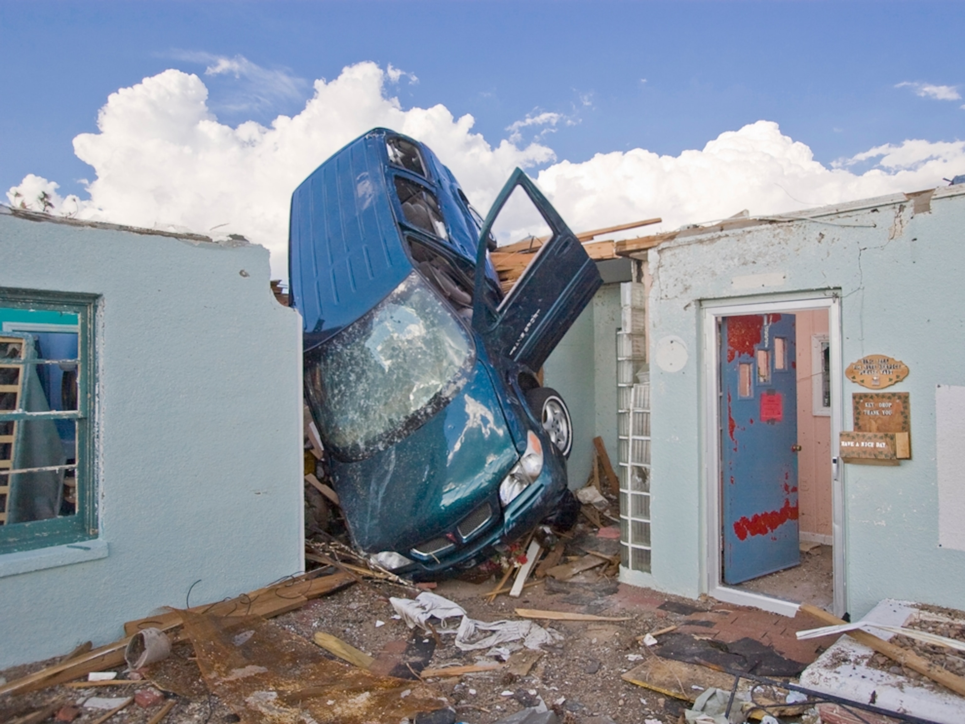 A blue van thrown into a building