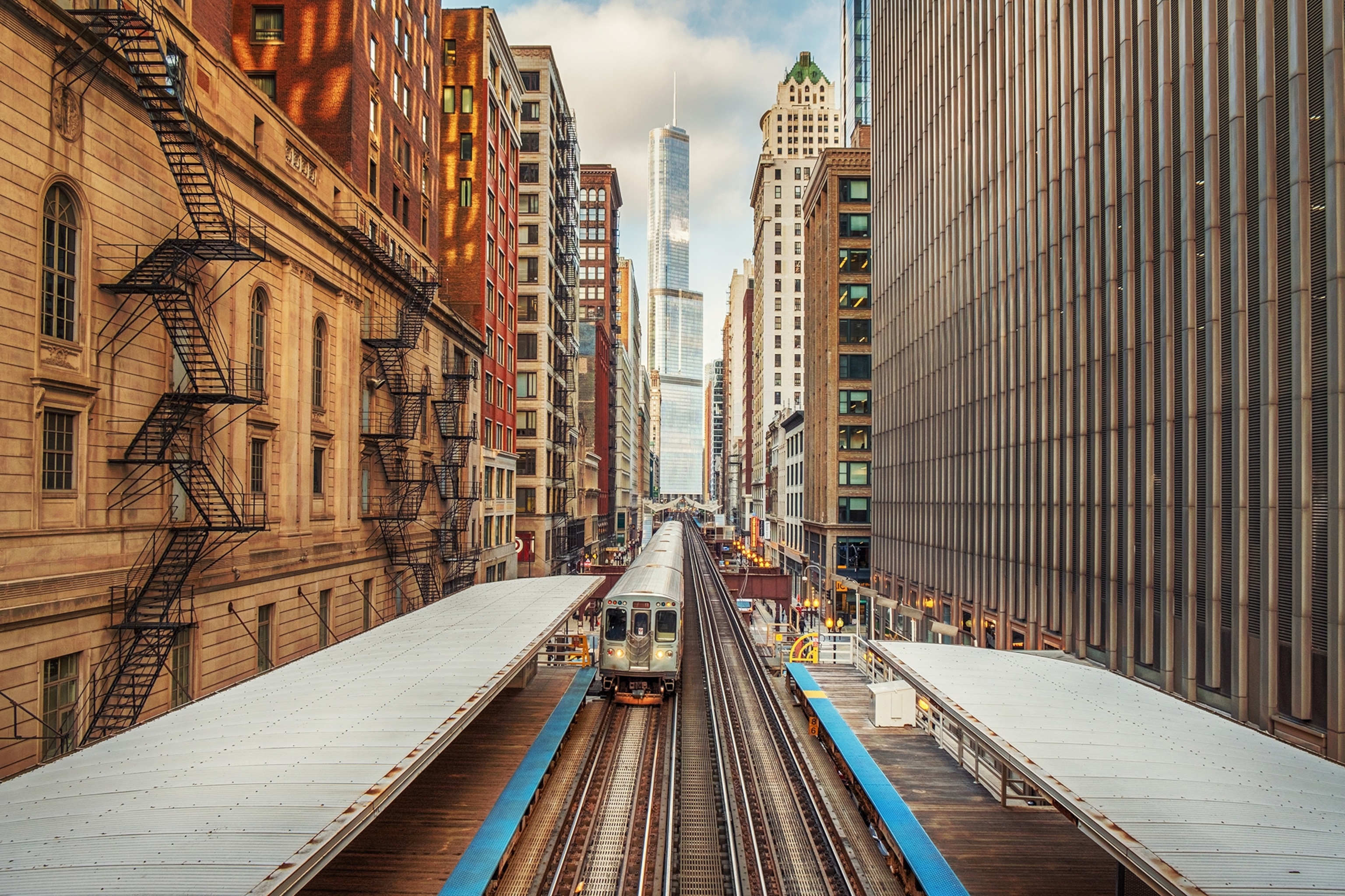 An industrial rail track, train and station in a building alley down Chicago's city centre.